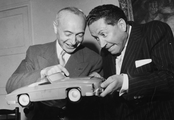 An uncharacteristically jovial J.A. Grégoire (on the left) showing his latest model to singer Jean Rigaux, circa 1956. (Photo by Keystone/Hulton Archive/Getty Images)
