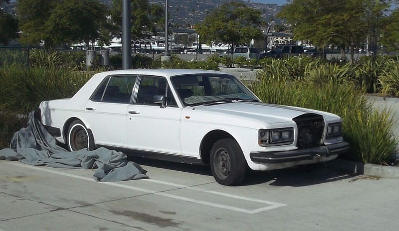 I’d driven by this car multiple times, but a car cover hid its classic lines. Still, the tall, boxy silhouette made it clear a Rolls Royce resided underneath.  Recently though, a wind storm conspired to blow off [&hellip;]