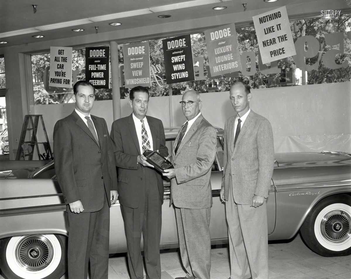 The official caption with this shot is: Columbus, Georgia, Dodge dealers in their showroom with one of the last 1958 models, getting ready for the ’59s. No wonder they look [&hellip;]