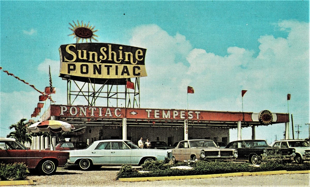Vintage Dealer Postcards: Sunshine Pontiac Sunshine Pontiac, Miami FL, in 1964; with a Googie architecture sign and umbrella decor.