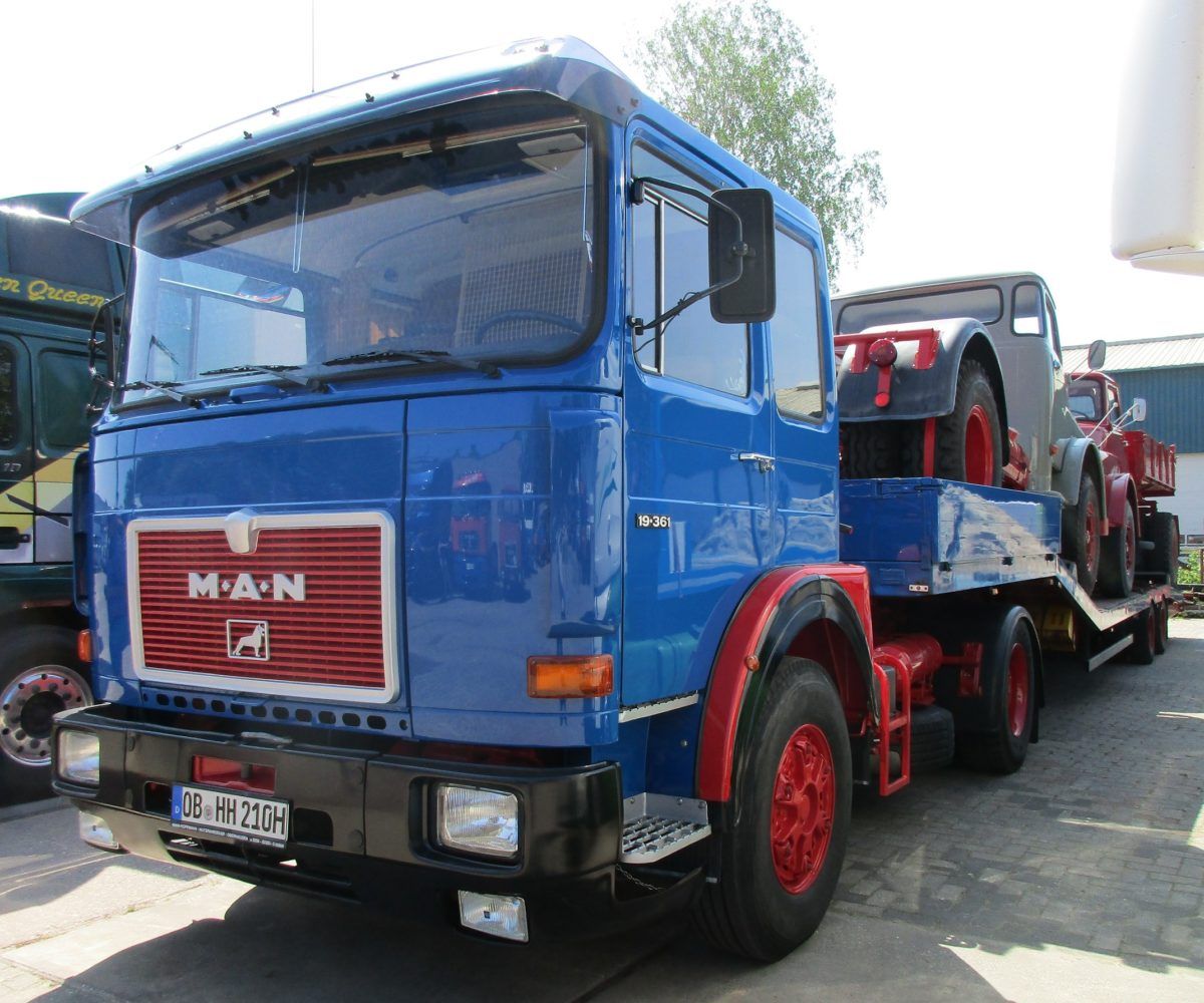Truck Stop Classics: MAN (Diesel) 19.361, 10.212, And 13.215 – Rolling Exhibition A trio of classic, heavy-duty MAN vehicles with friendly, rounded shapes. Toughness masked by soft looks, this especially applies to the duo sitting on the semi-low loader.