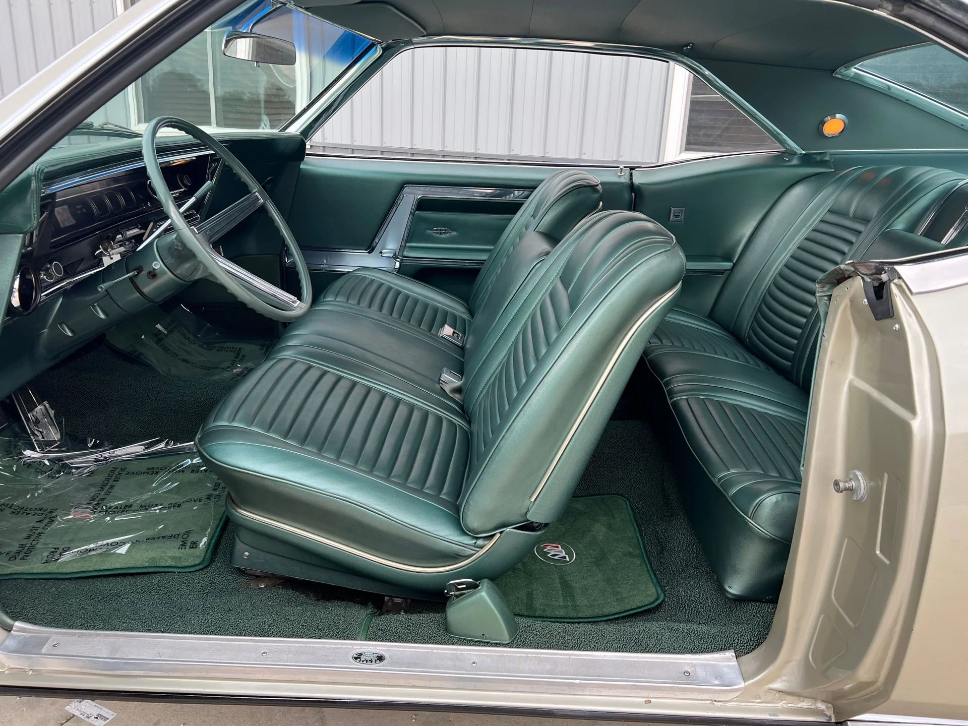 1966 Buick Riviera Versus 1966 Oldsmobile Toronado – Closely Related, Yet So Different (Part 2) 8 Custom Trim Strato Bench seat in a Silver Green 1966 Buick Riviera with green interior, viewed through the driver's door