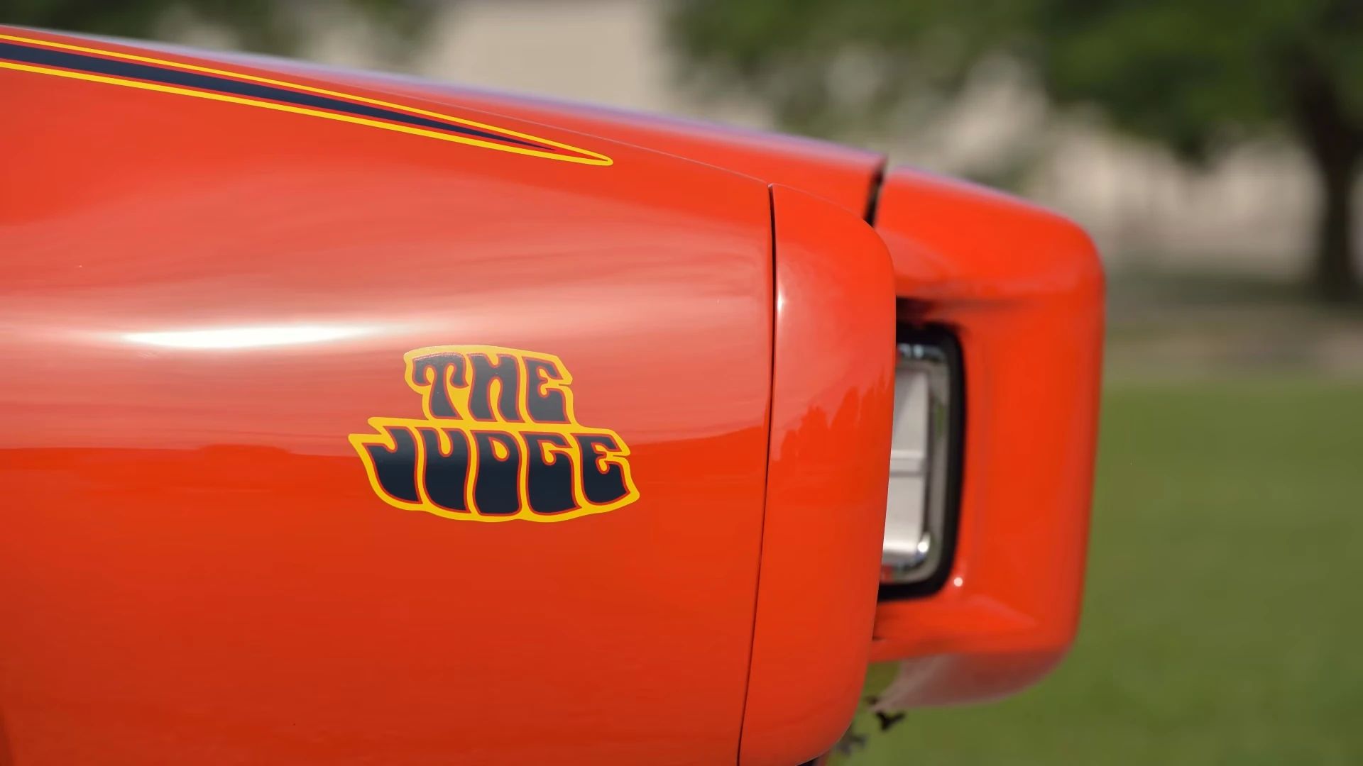 The Judge decal on the right side of the nose of a Carousel Red 1969 Pontiac GTO with Endura nose and concealed headlights