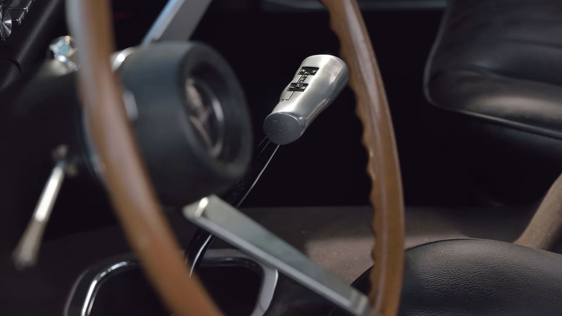 Dashboard of a 1969 Pontiac GTO Judge with black interior, Custom Sports steering wheel, and 4-speed