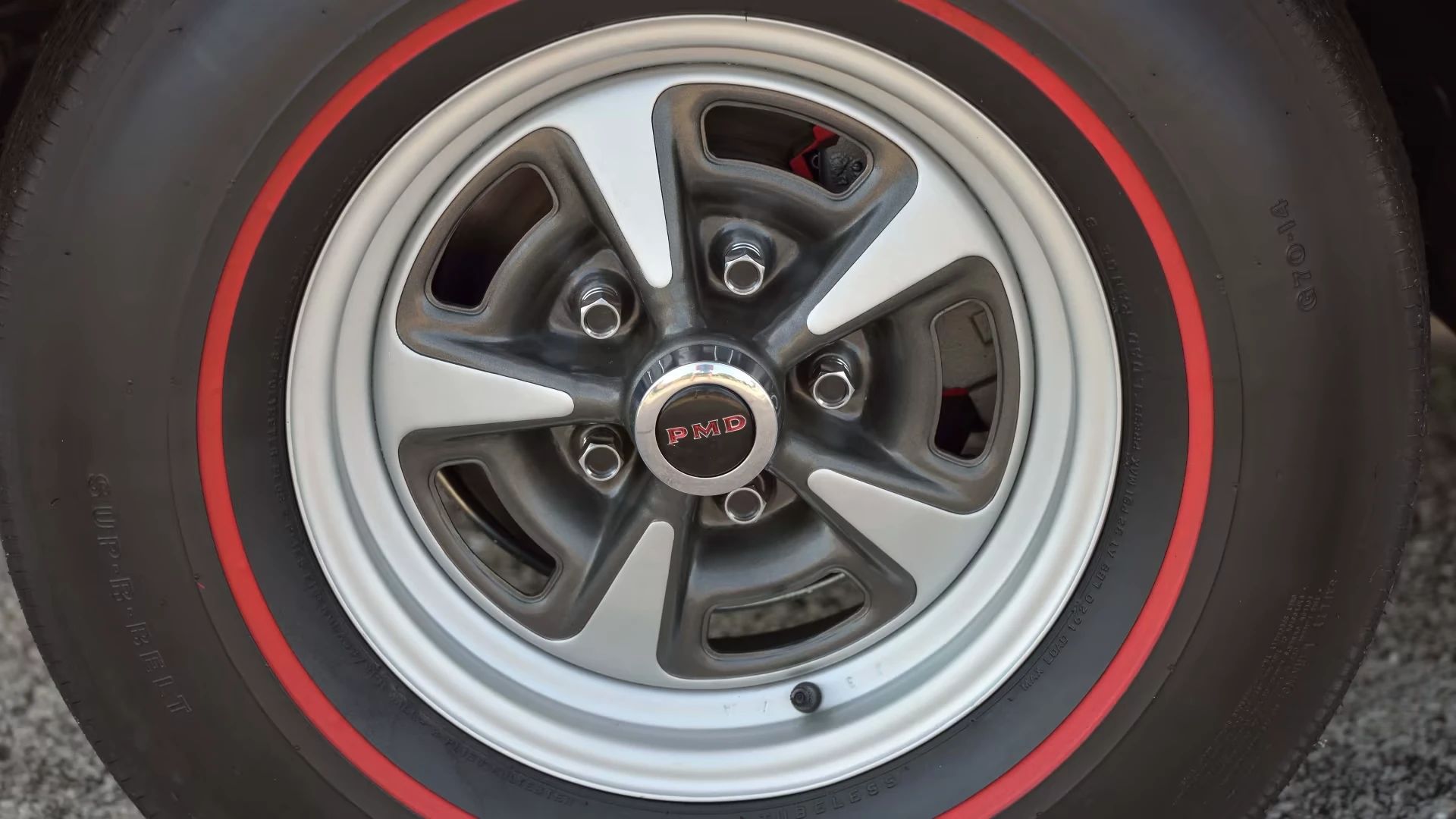  Closeup of redline tire and Rally II wheel on a Carousel Red 1969 Pontiac GTO