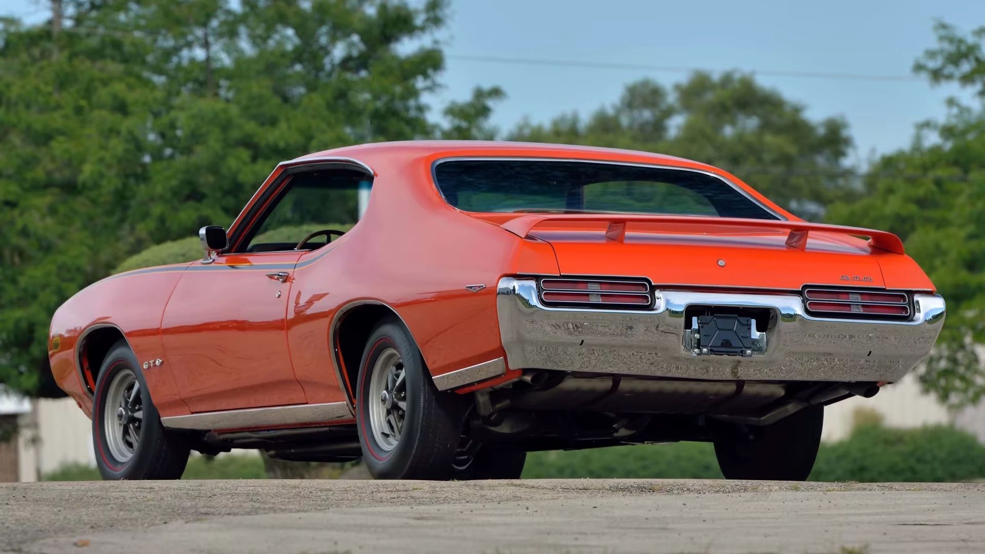 Left rear 3q view of a Carousel Red 1969 Pontiac GTO Judge hardtop with Rally II wheels