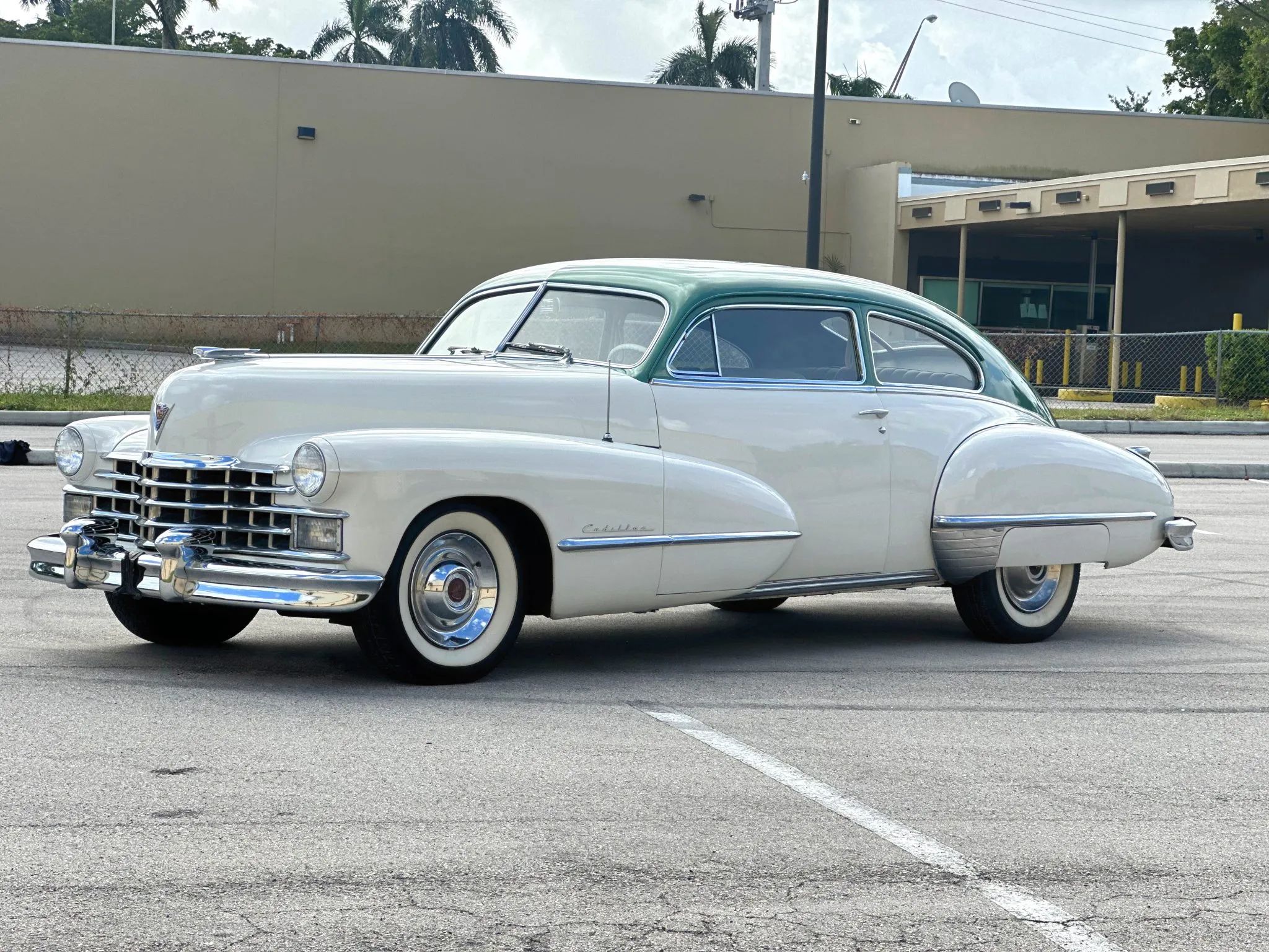 Left front 3q view of a white 1947 Cadillac Series 61 club coupe with a green roof