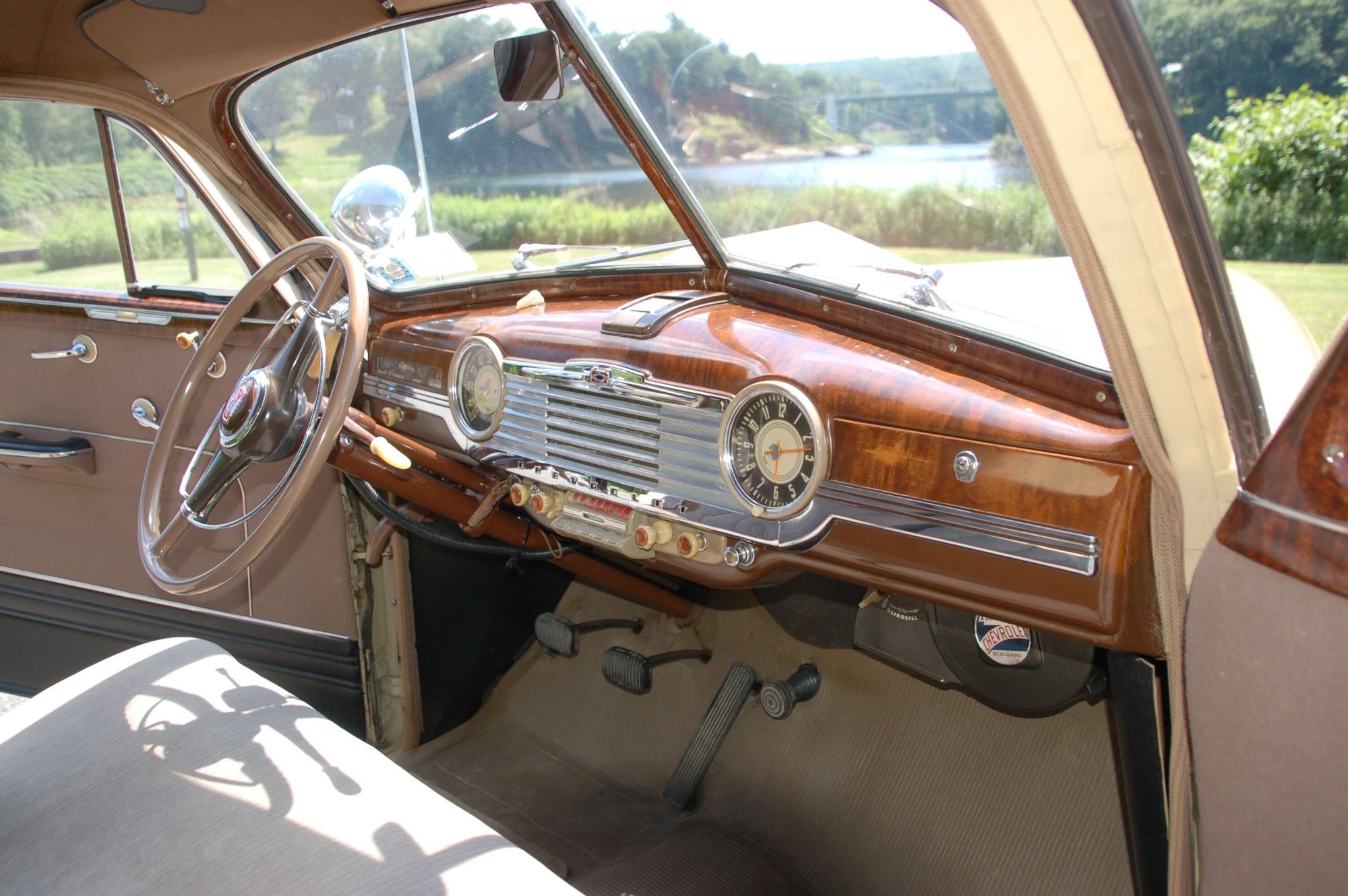 Dashboard of a 1947 Chevrolet Fleetmaster Master DeLuxe coupe with tan cloth upholstery, viewed through the passenger door