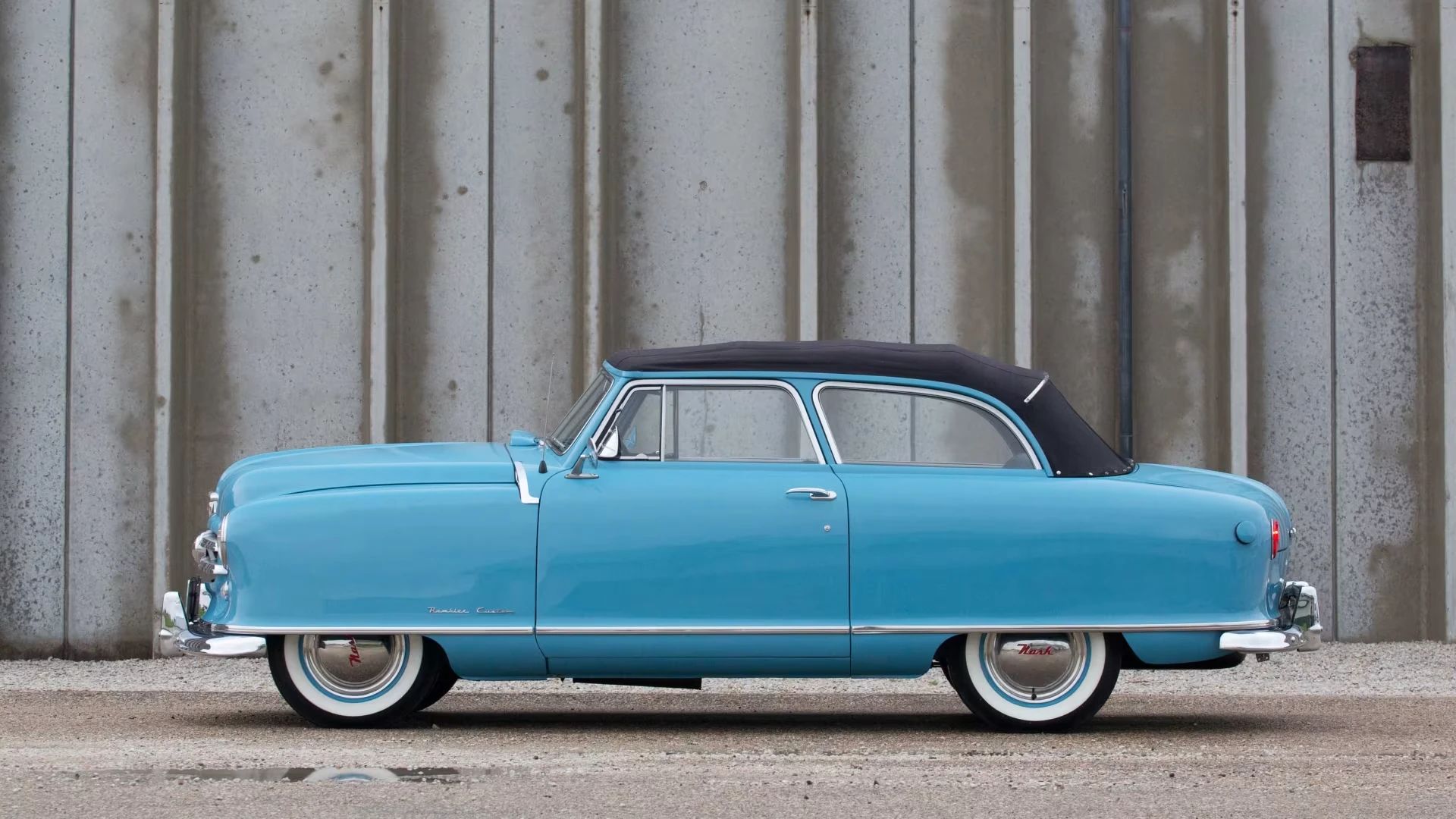 "Don't Try This With A Conventional Convertible" 4 Left side view of a blue 1950 Nash Rambler convertible with the top up