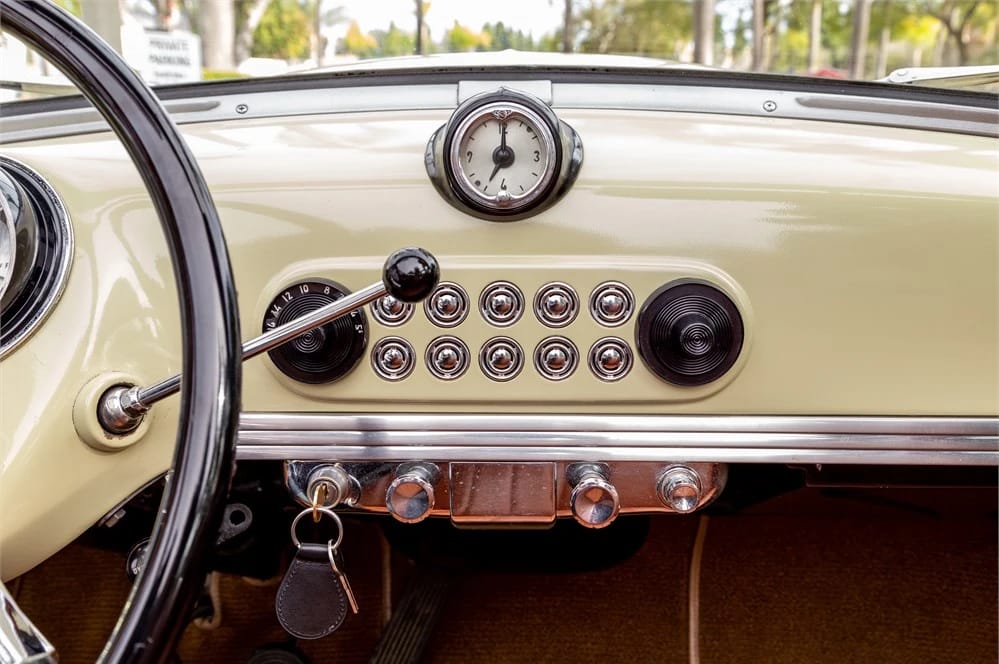 1950 Nash Rambler Convertible Landau: Adorable, Thrifty, But Not Cheap 10 Close-up of the dash of a 1950 Nash Rambler with ivory interior, showing the clock, shift lever, radio, and speaker, and cigar lighter
