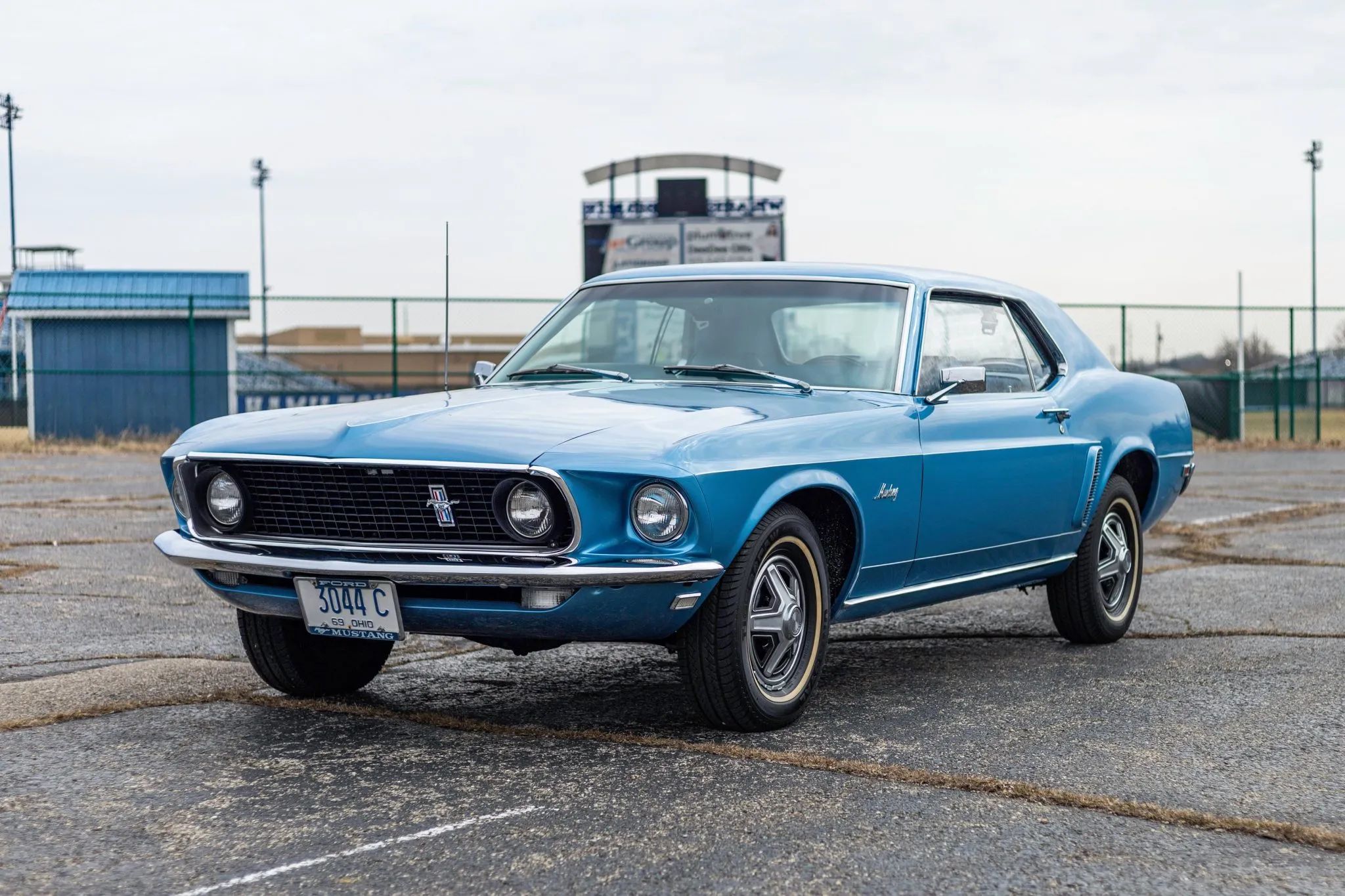 Left front 3q view of a Winter Blue 1969 Ford Mustang hardtop with 14-inch wheelcovers