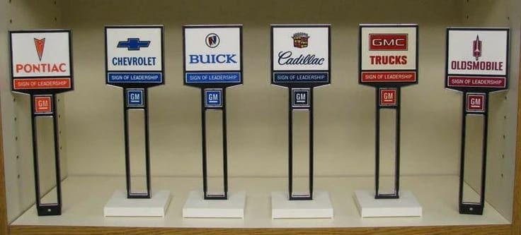 What Cars And Trucks Did Americans Buy In 1969? – A CC Auto Yearbook Feature 14 Row of vintage GM dealer desk signs for Pontiac, Chevrolet, Buick, Cadillac, GMC Trucks, and Oldsmobile