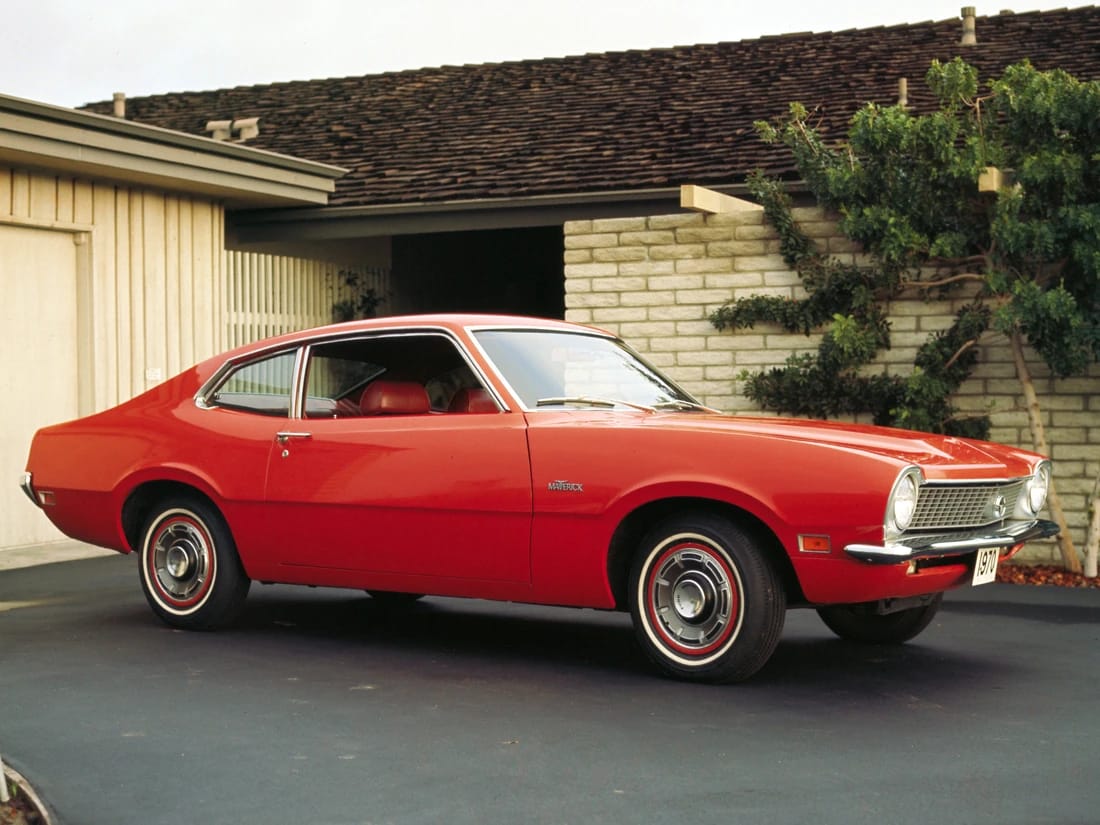 Press shot of a red 1970 Ford Maverick parked in a driveway