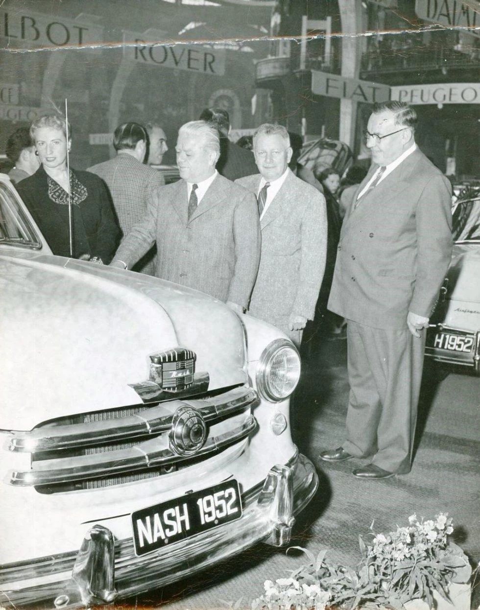 1950 Nash Rambler Convertible Landau: Adorable, Thrifty, But Not Cheap 17 Scanned B&W photo of a white woman and three white men standing behind the hood of a Nash with a "1952" license plate