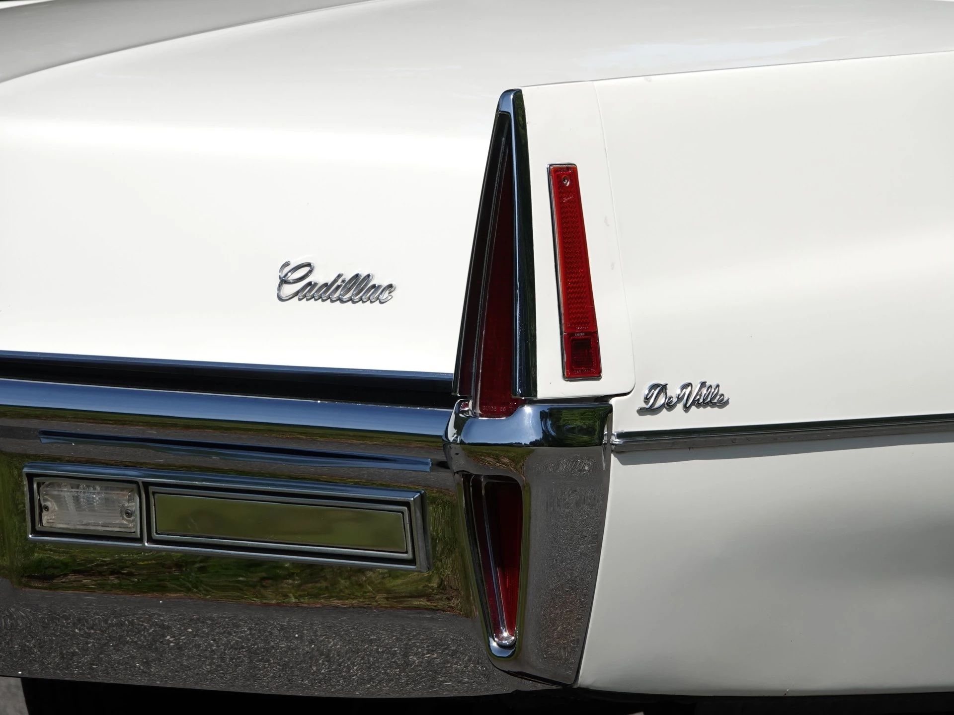 Decade De Ville: Cadillac's Bestselling '70s De Villes 2 Right rear taillight of a white Cadillac De Ville convertible, showing the "Cadillac" and "De Ville" script badges