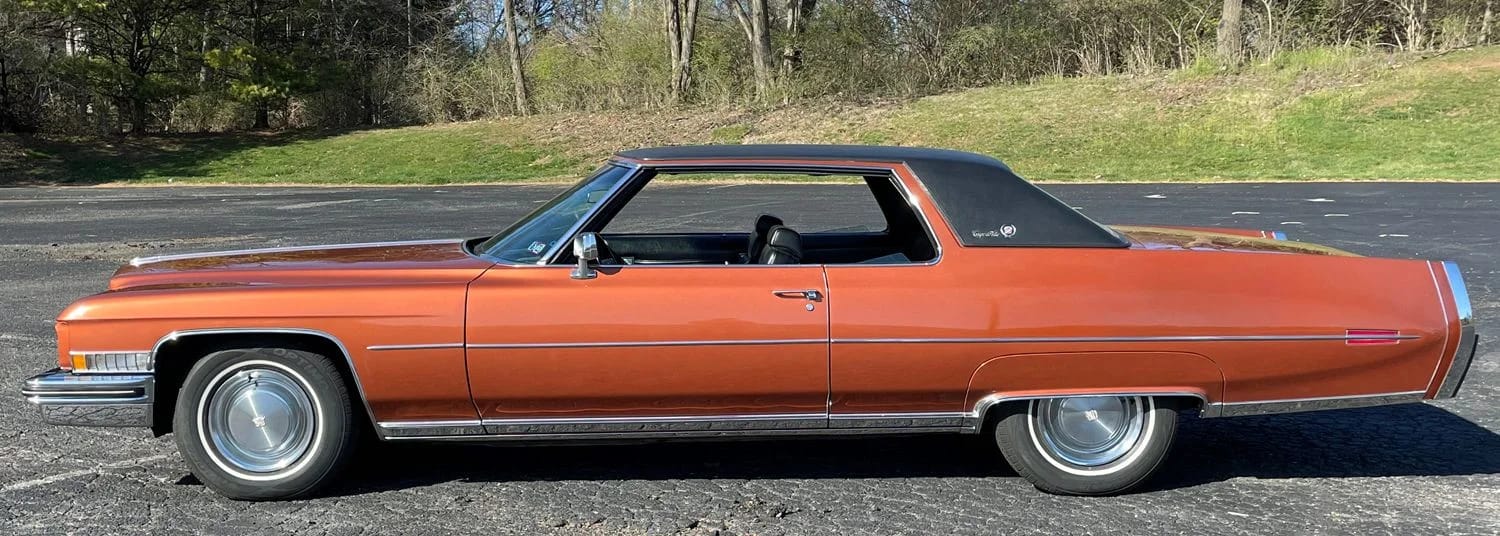 Decade De Ville: Cadillac's Bestselling '70s De Villes 10 Left side view of an orange 1973 Cadillac Coupe de Ville with a black vinyl top