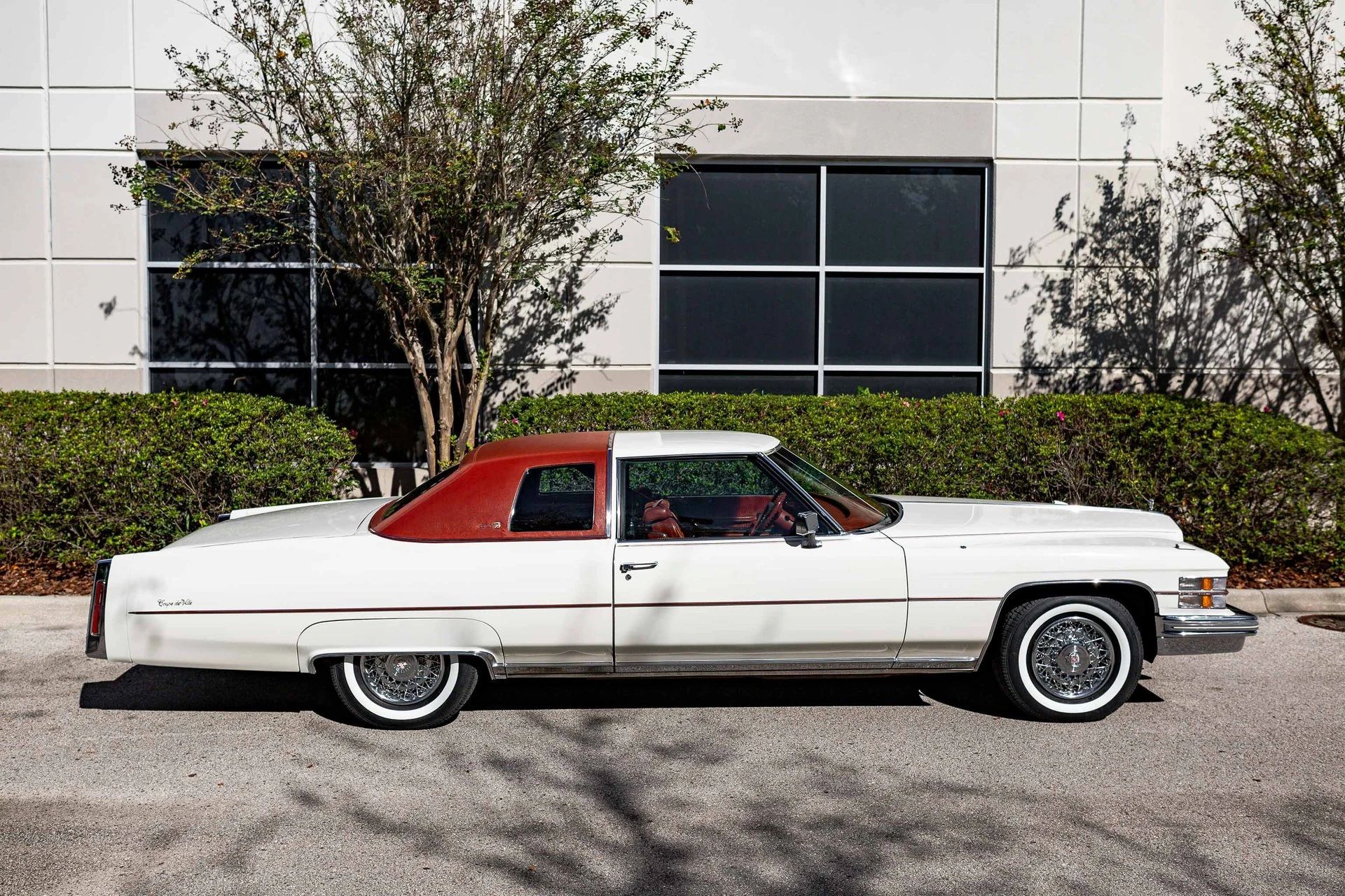 Decade De Ville: Cadillac's Bestselling '70s De Villes 11 High-angle right side view of a white 1974 Cadillac Coupe de Ville with an orange vinyl top
