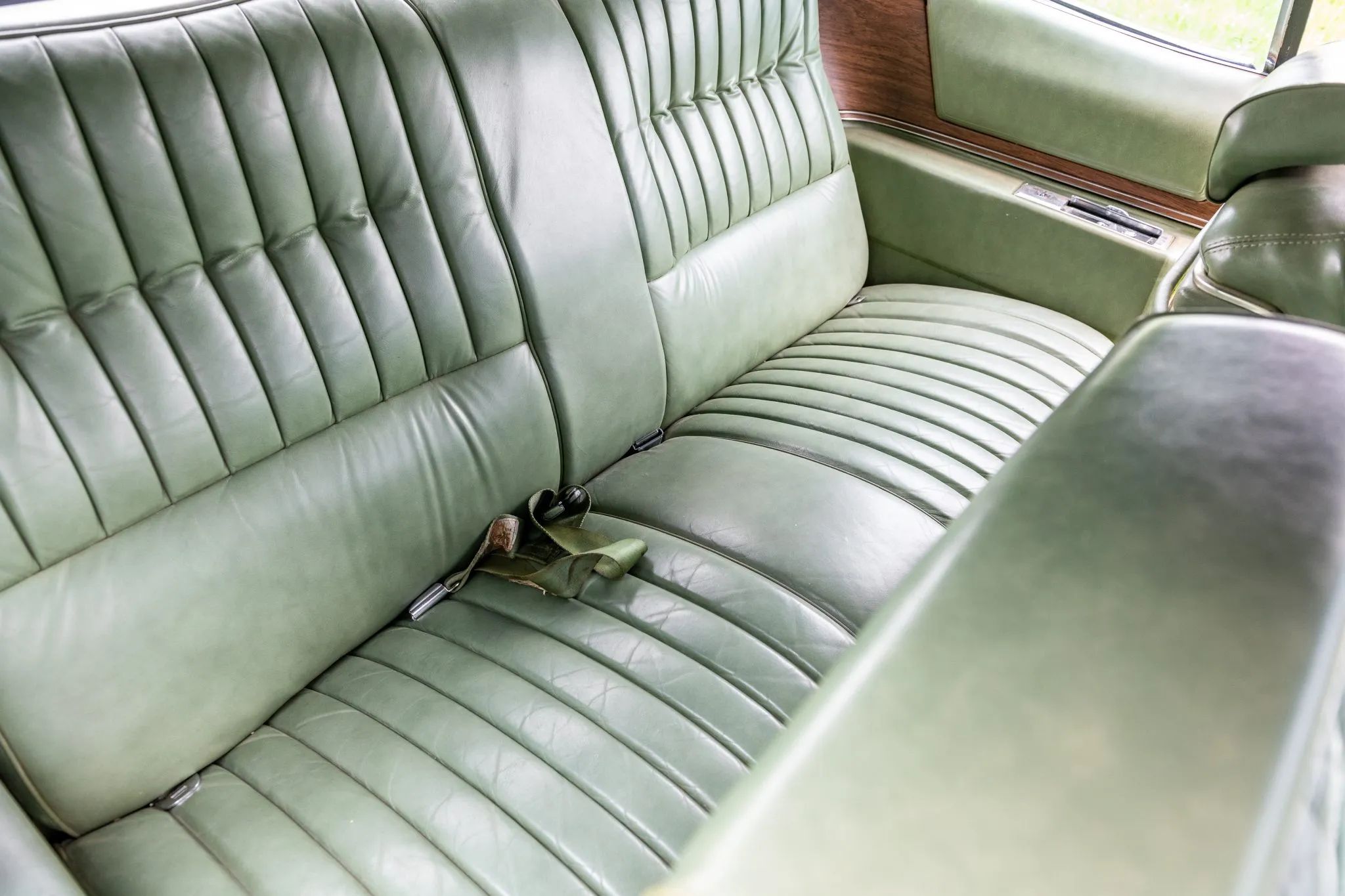 Back seat of a 1974 Cadillac Eldorado with green leather