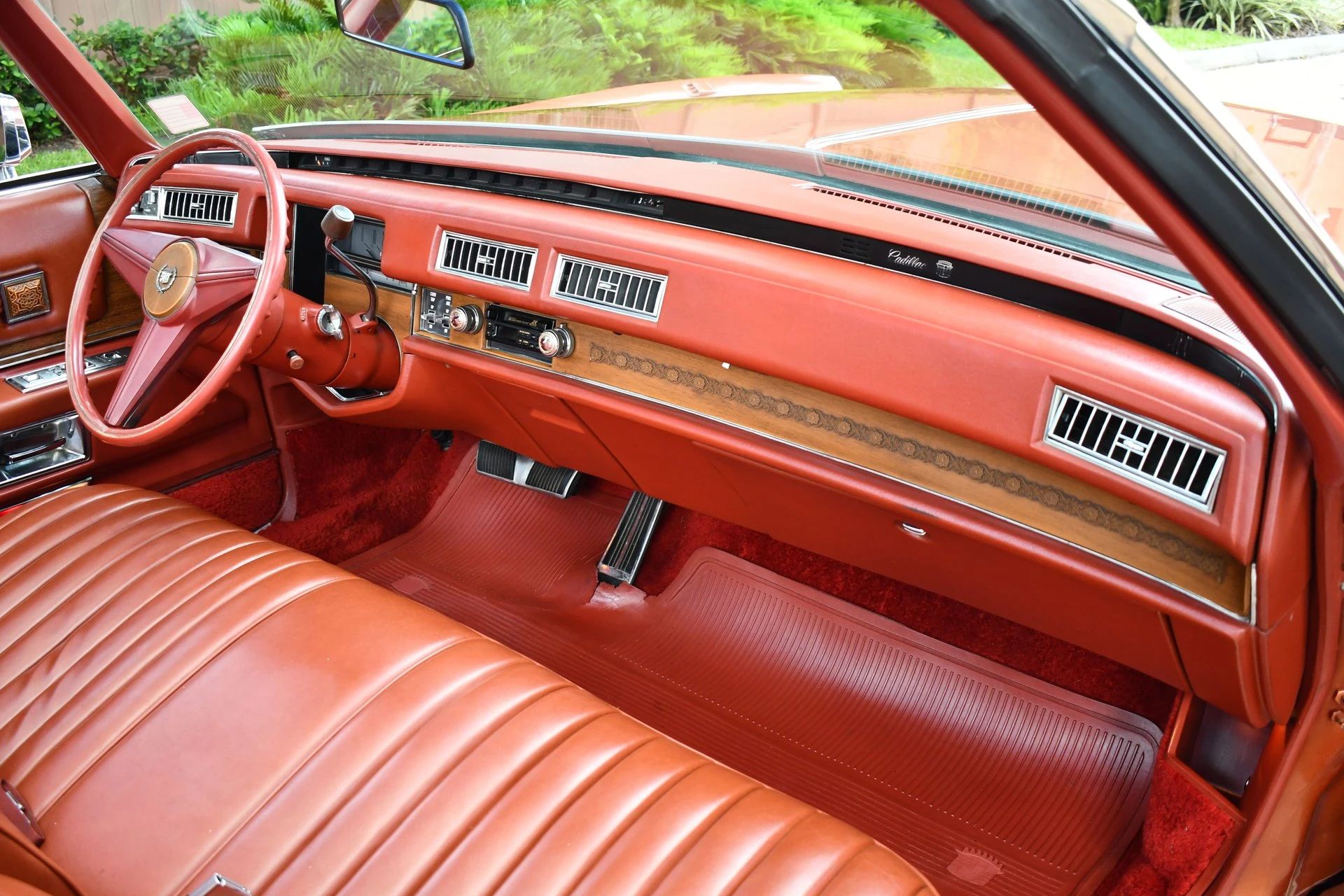 Dashboard and front seat of an Andes Copper 1974 Cadillac Eldorado convertible with orange dash and leather