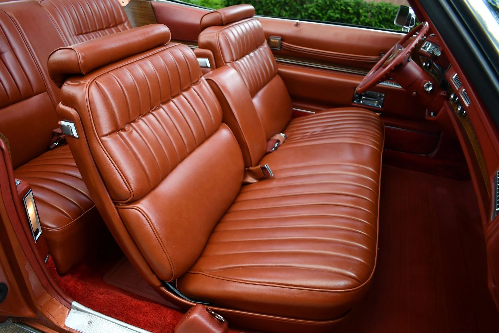 Front seat of a 1974 Cadillac Eldorado convertible with orange leather
