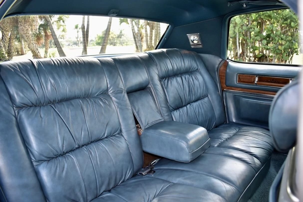 Back seat of a 1975 Cadillac Fleetwood Brougham with blue leather
