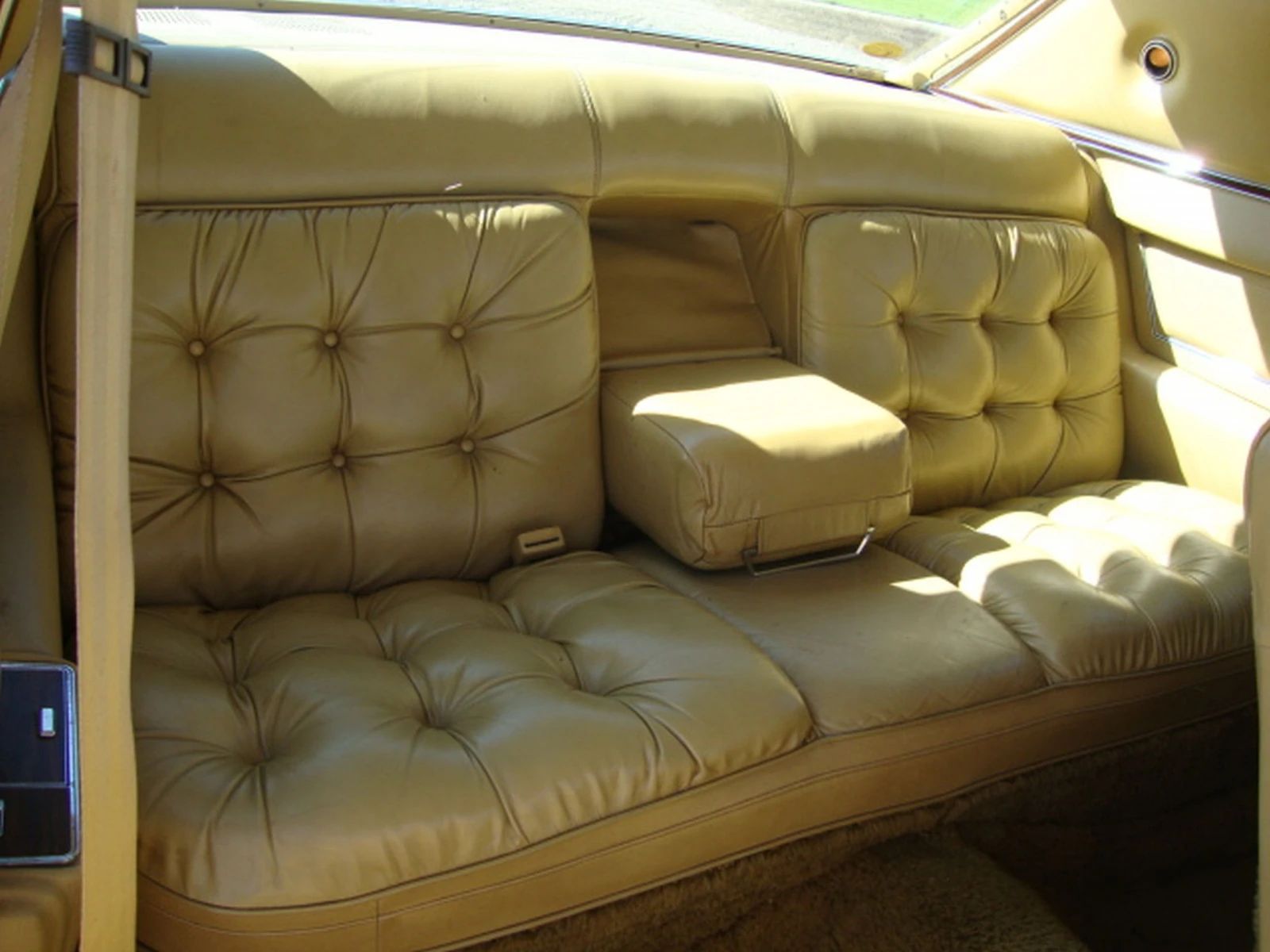 Back seat of a 1975 Imperial LeBaron with gold leather