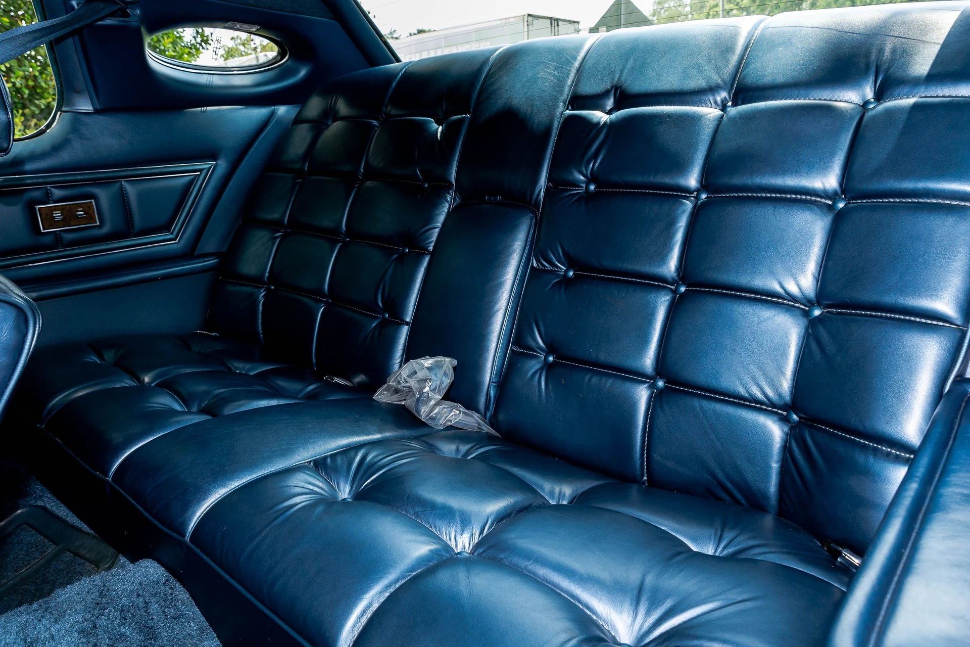 Back seat of a 1975 Lincoln Continental Mark IV with dark blue leather