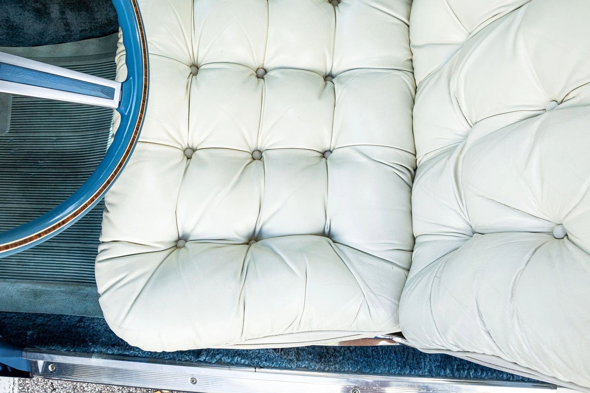 White leather seat of a 178 Chrysler New Yorker with blue carpeting and a blue steering wheel