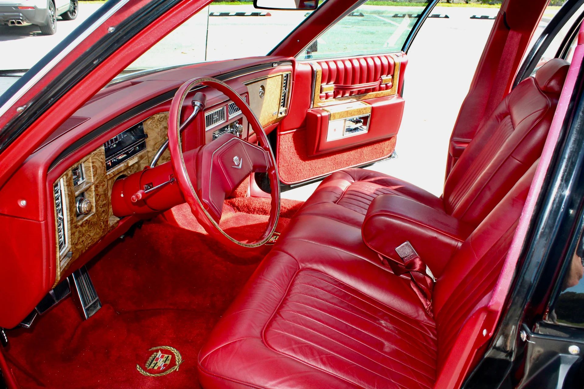 Front seat and dashboard of a 1979 Cadillac Sedan de Ville with red leather