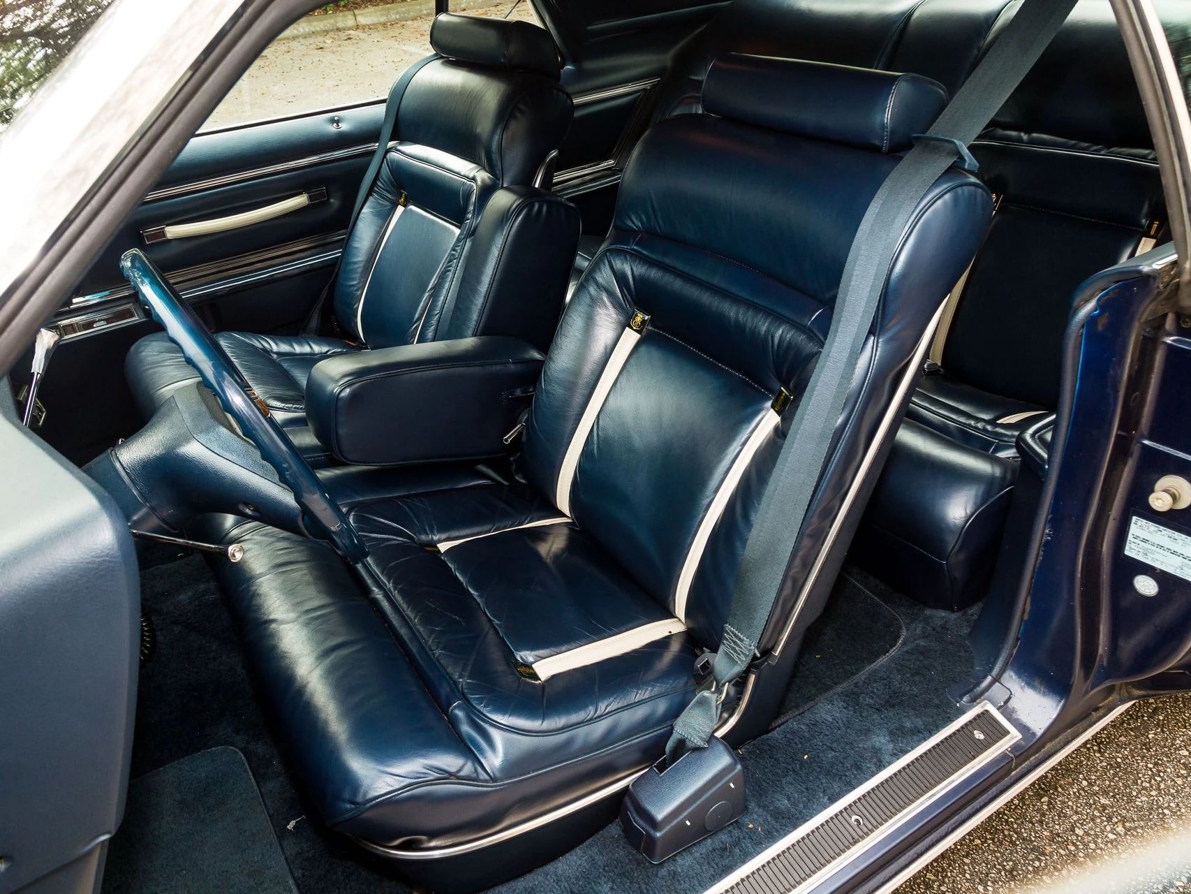 Front seat of a 1979 Lincoln Continental Mark V with dark blue leather seats and white accents