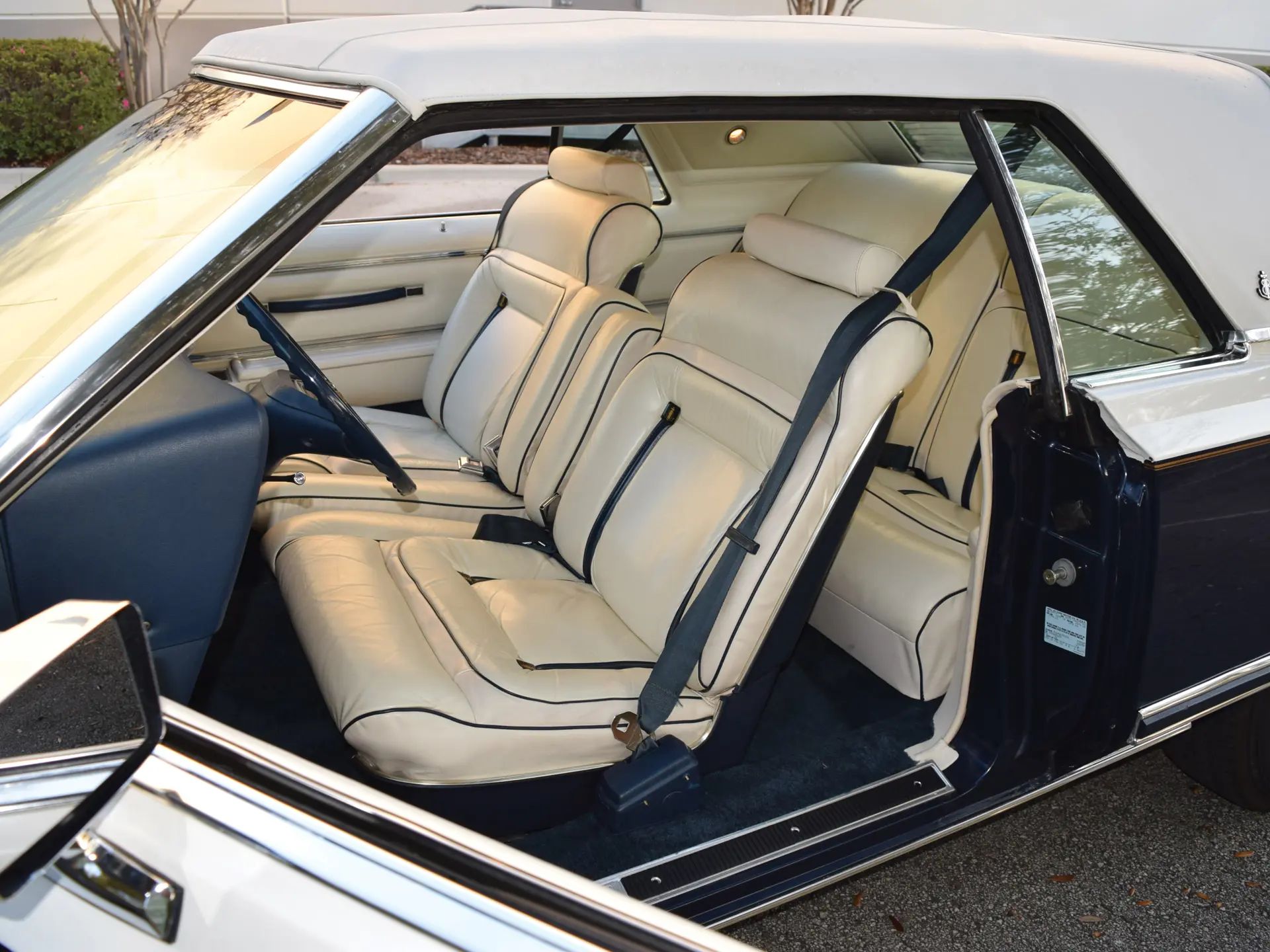 Front seat of a 1979 Lincoln Continental Mark V with white leather seats and dark blue accents