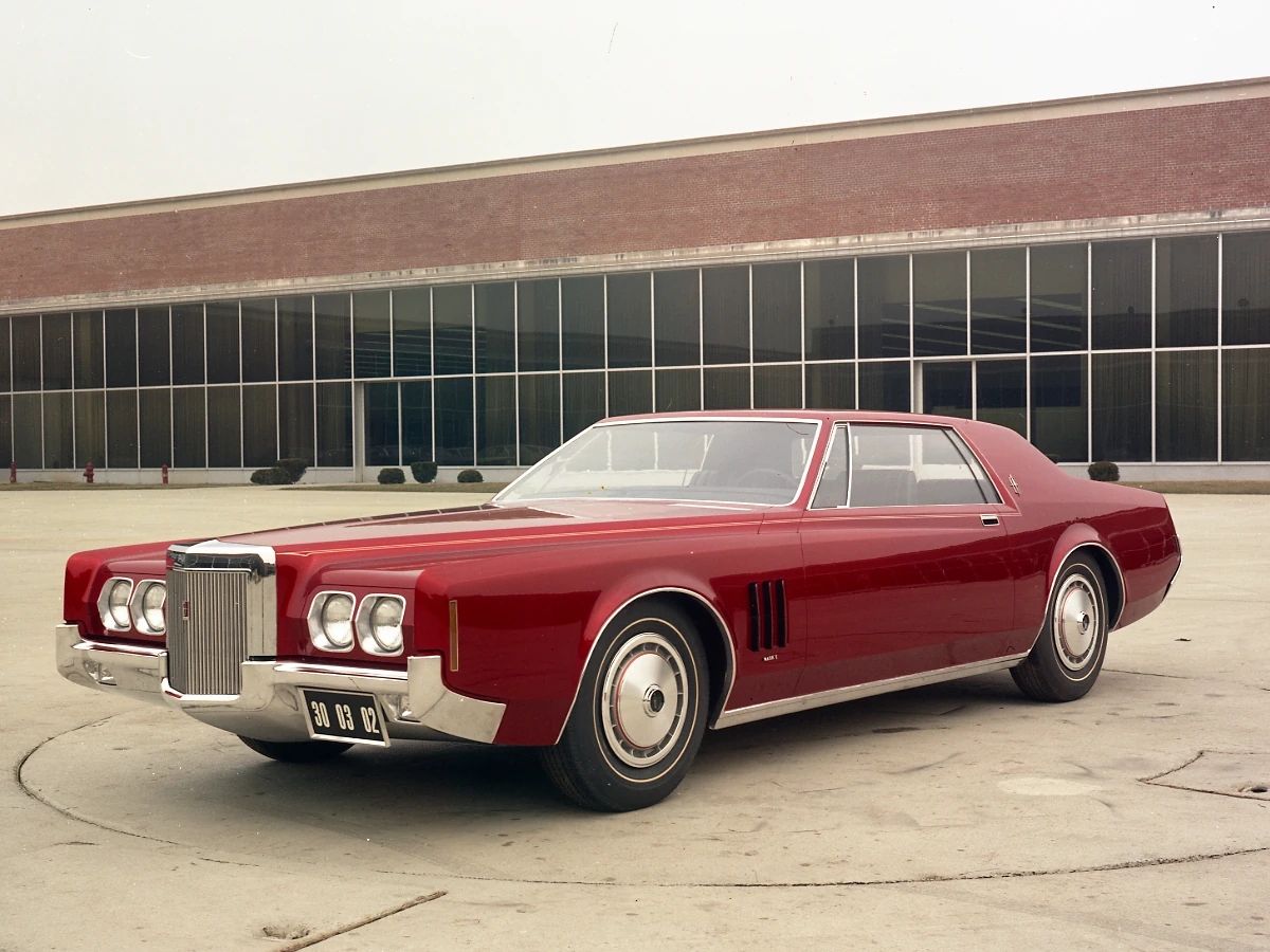 1977 Lincoln Continental Mark V: Bigger Than Ever, This Defiant Dinosaur Was Rolling In Green 6 Front 3q view of a dark red styling model of a Lincoln Continental Mark looking a lot like a 1969 Pontiac Grand Prix, parked outside in front of the Ford Design Center