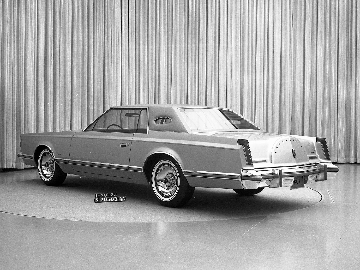 1977 Lincoln Continental Mark V: Bigger Than Ever, This Defiant Dinosaur Was Rolling In Green 9 B&W studio shot showing a rear 3q view of a Lincoln Mark V full-size model parked in front of a curtain
