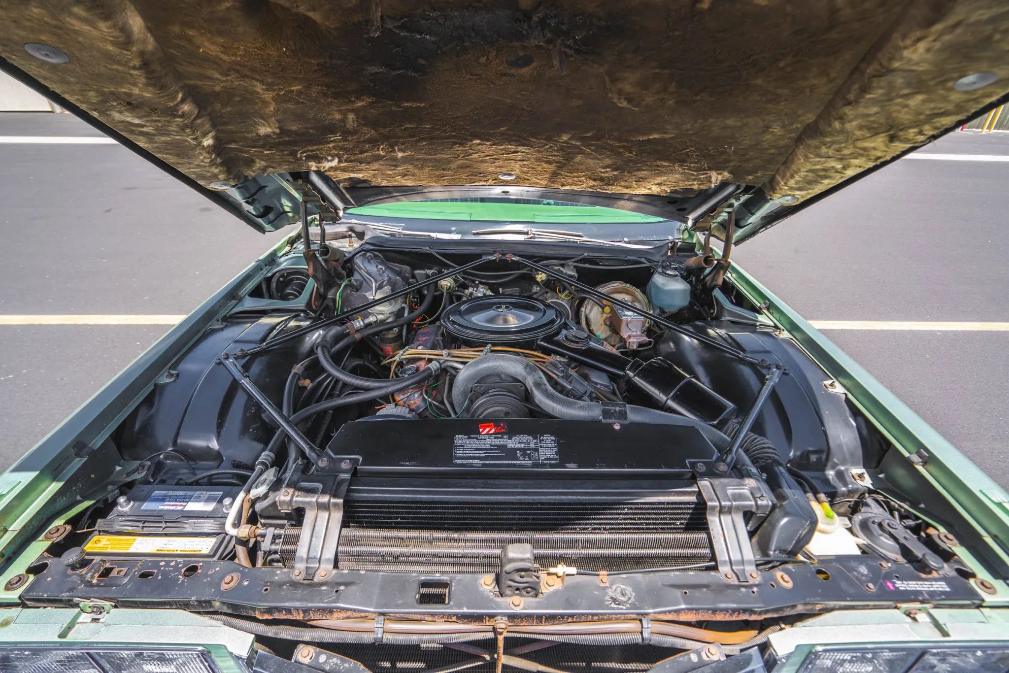 Decade De Ville: Cadillac's Bestselling '70s De Villes 12 Cadillac V-8 engine under the raised hood of a green 1975 Cadillac