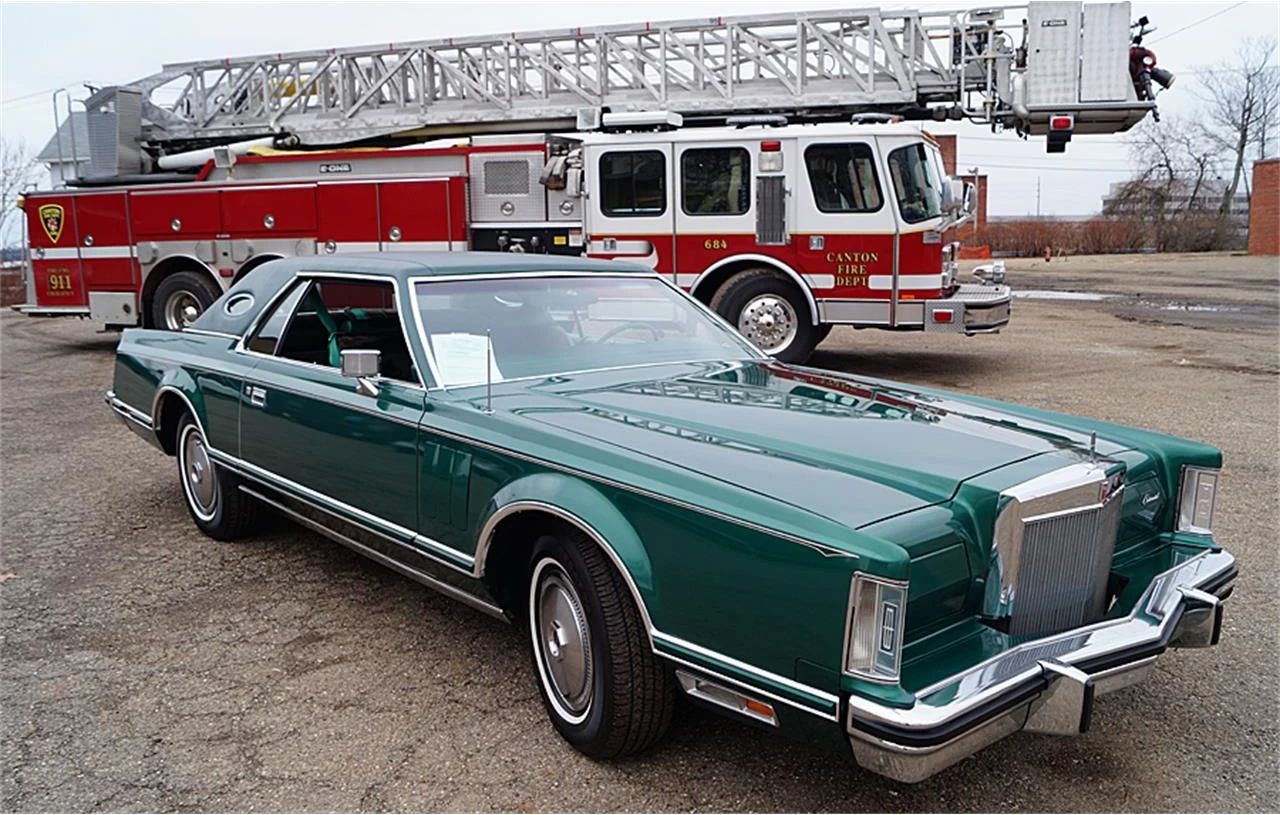 1977 Lincoln Continental Mark V: Bigger Than Ever, This Defiant Dinosaur Was Rolling In Green 4 Front 3q view of a green 1977 Lincoln Continental Mark V with a fire truck parked behind it