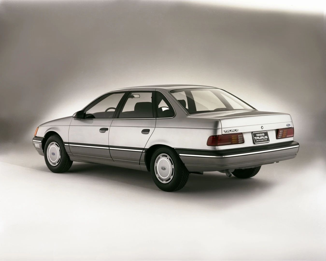 1960–1962 Plymouth Valiant Versus 1986–1991 Ford Taurus – Closer Than They Appear 29 Studio rear 3q view of a silver 1986 Ford Taurus LX sedan