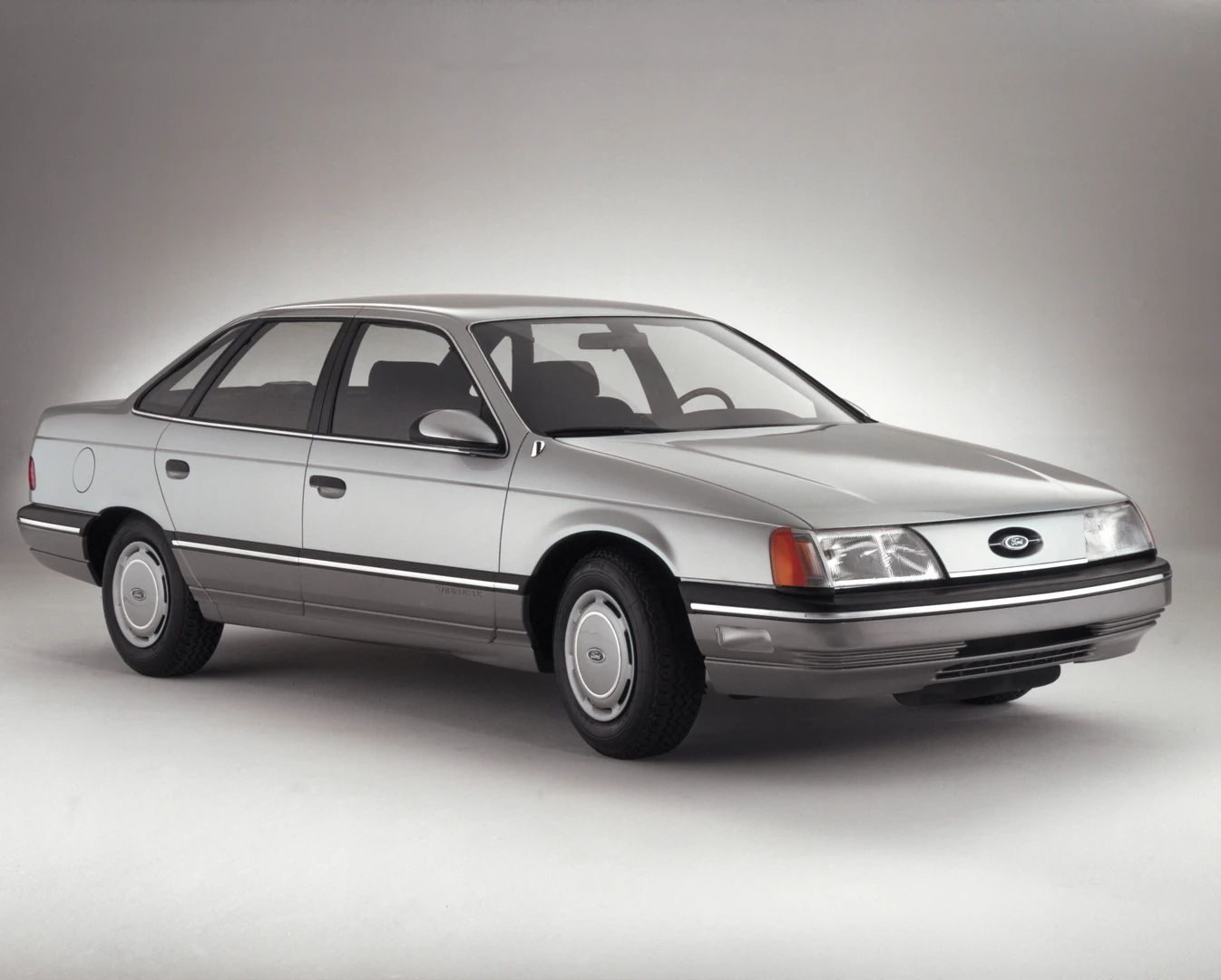 1960–1962 Plymouth Valiant Versus 1986–1991 Ford Taurus – Closer Than They Appear 28 Studio right front 3q view of a silver 1986 Ford Taurus LX sedan