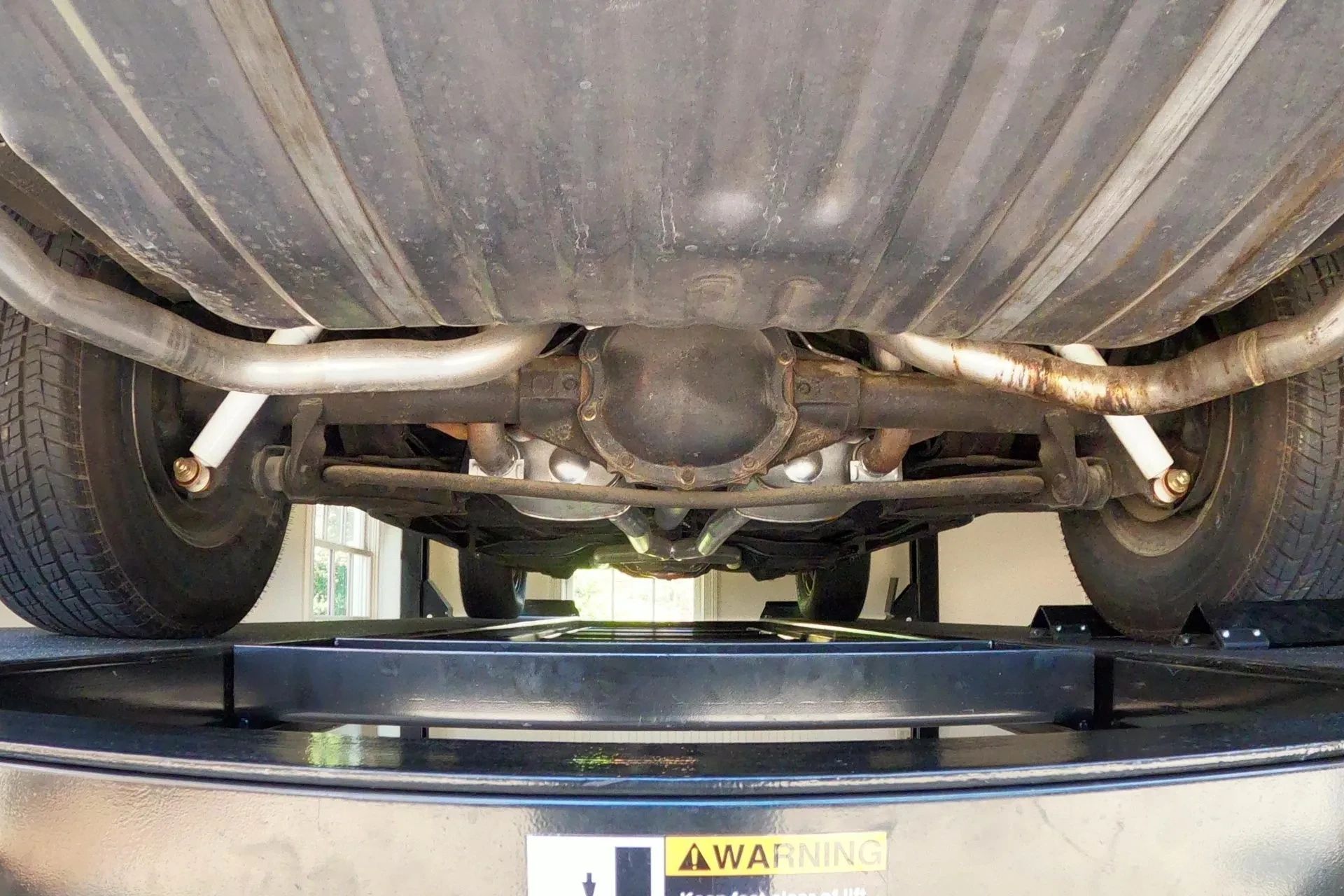 Rear anti-roll bar and rear axle of a 1966 Oldsmobile 4-4-2, seen from below with the car on a hoist