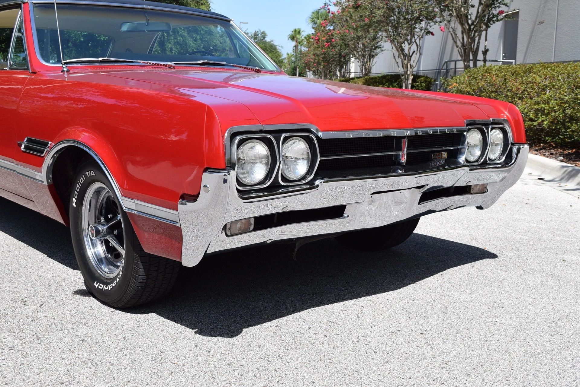 Nose of a red 1966 Oldsmobile 4-4-2 with Super Stock chromed wheels