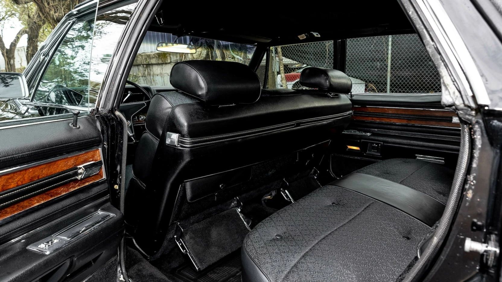Color-Coordinated Cadillacs: Colorful Eldorados, De Villes, And Fleetwood Broughams 6 Back seat of a 1968 Cadillac Fleetwood Brougham with black cloth upholstery and folding footrests