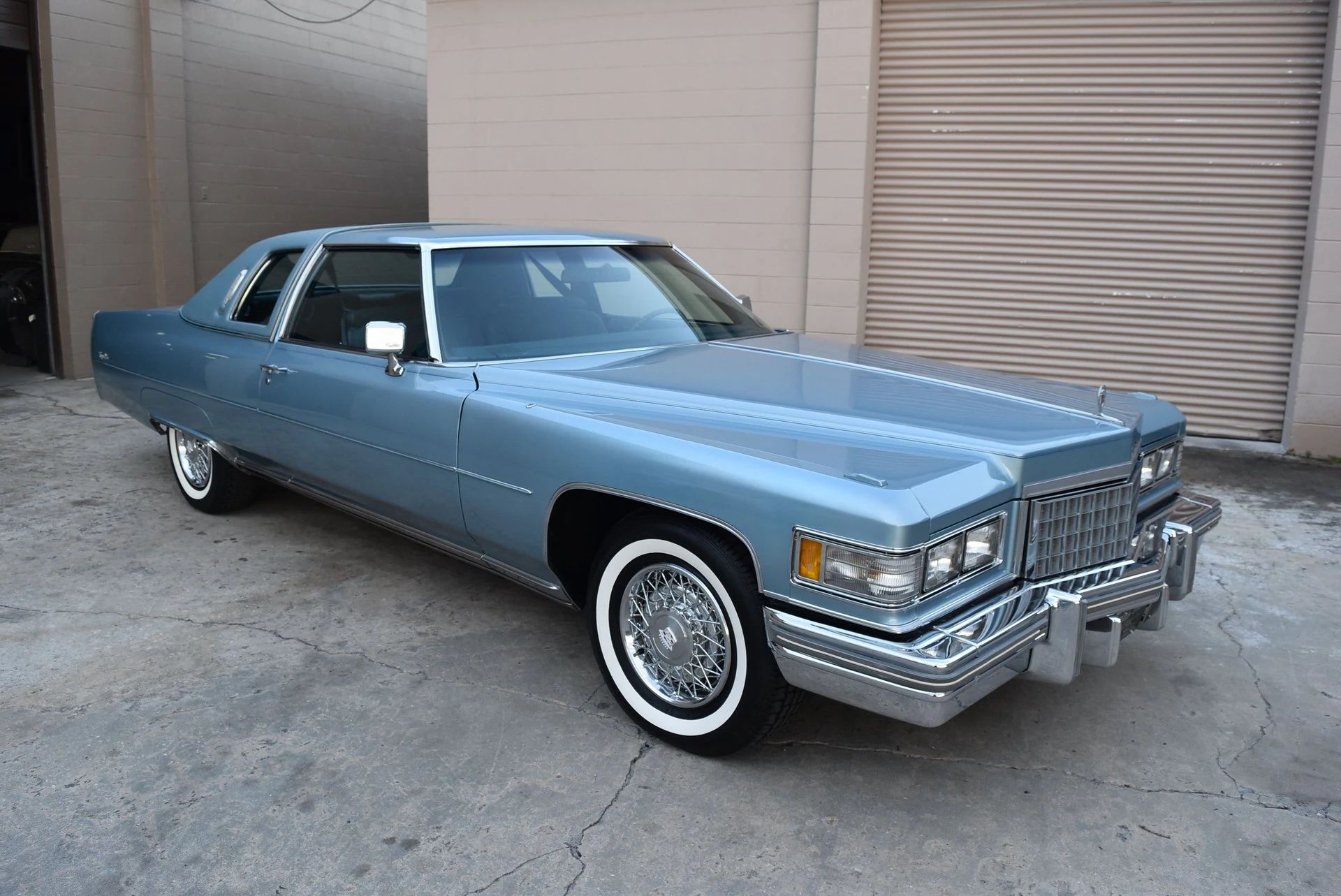 Color-Coordinated Cadillacs: Colorful Eldorados, De Villes, And Fleetwood Broughams 20 Right front 3q view of a blue 1976 Cadillac Coupe de Ville parked in an alley
