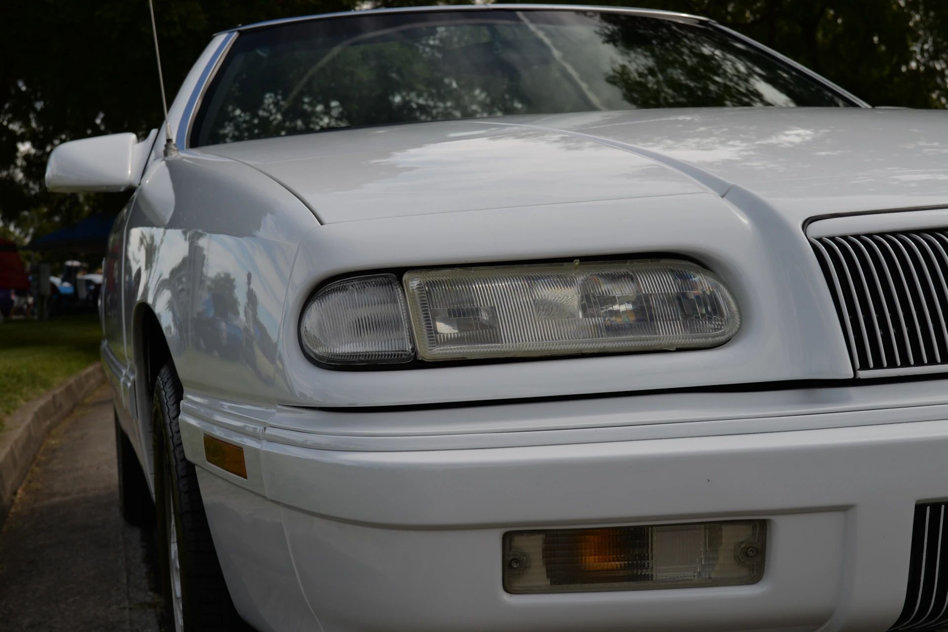 1994–1995 Chrysler LeBaron GTC Convertible – A Rental Car Favorite Nears Its Final Curtain 6 Closeup of the headlight of a white 1994 or 1995 Chrysler LeBaron