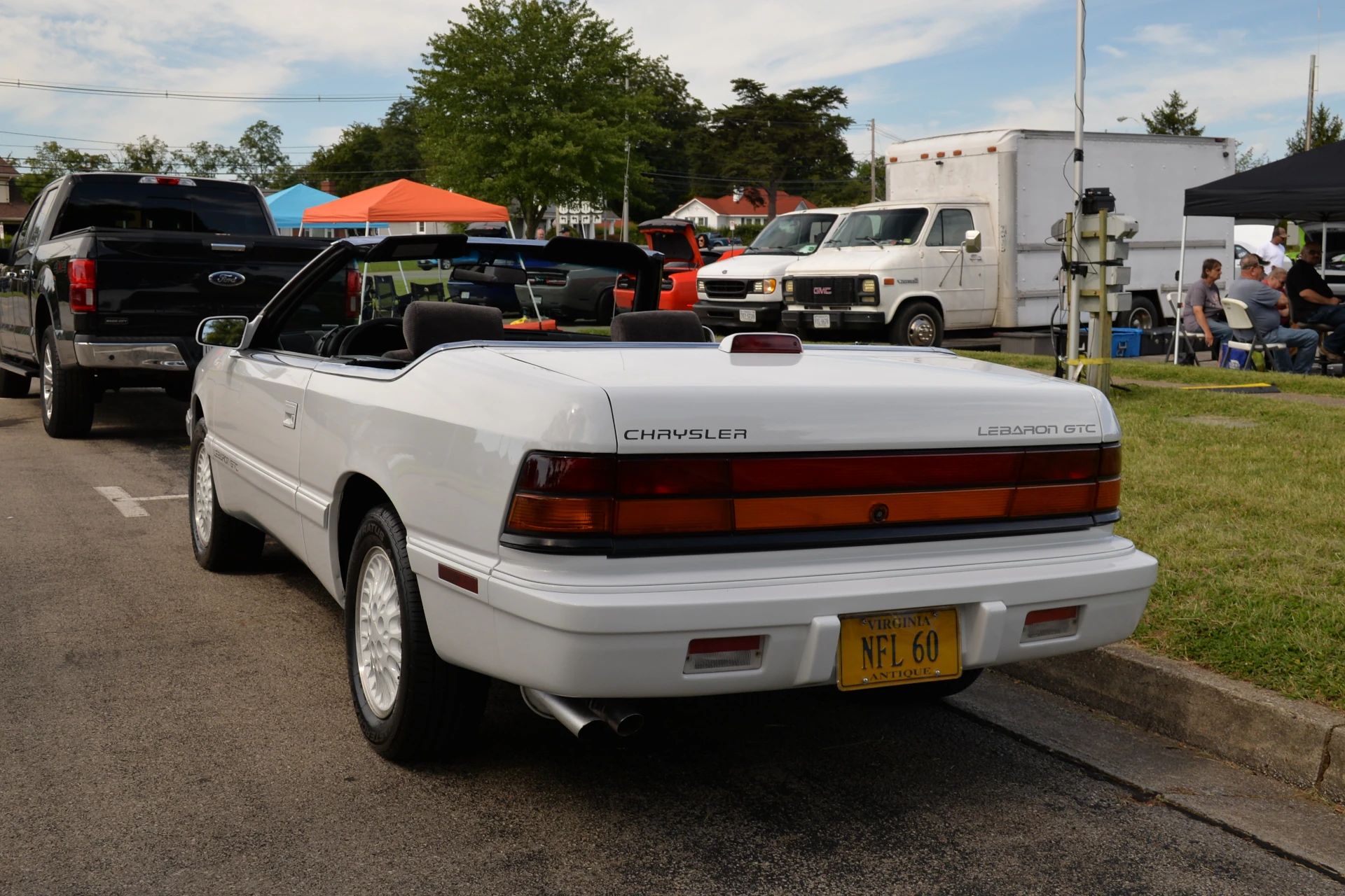 1994–1995 Chrysler LeBaron GTC Convertible – A Rental Car Favorite Nears Its Final Curtain 7 Rear 3q view of a white 1994 or 1995 Chrysler LeBaron convertible with the top down and matching white alloy wheels; its Virginia antique license plate reads NFL 60