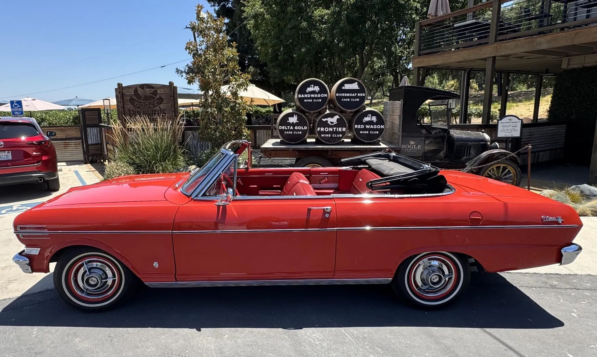 Left side view of a red 1962 Chevrolet Chevy II convertible with the top down