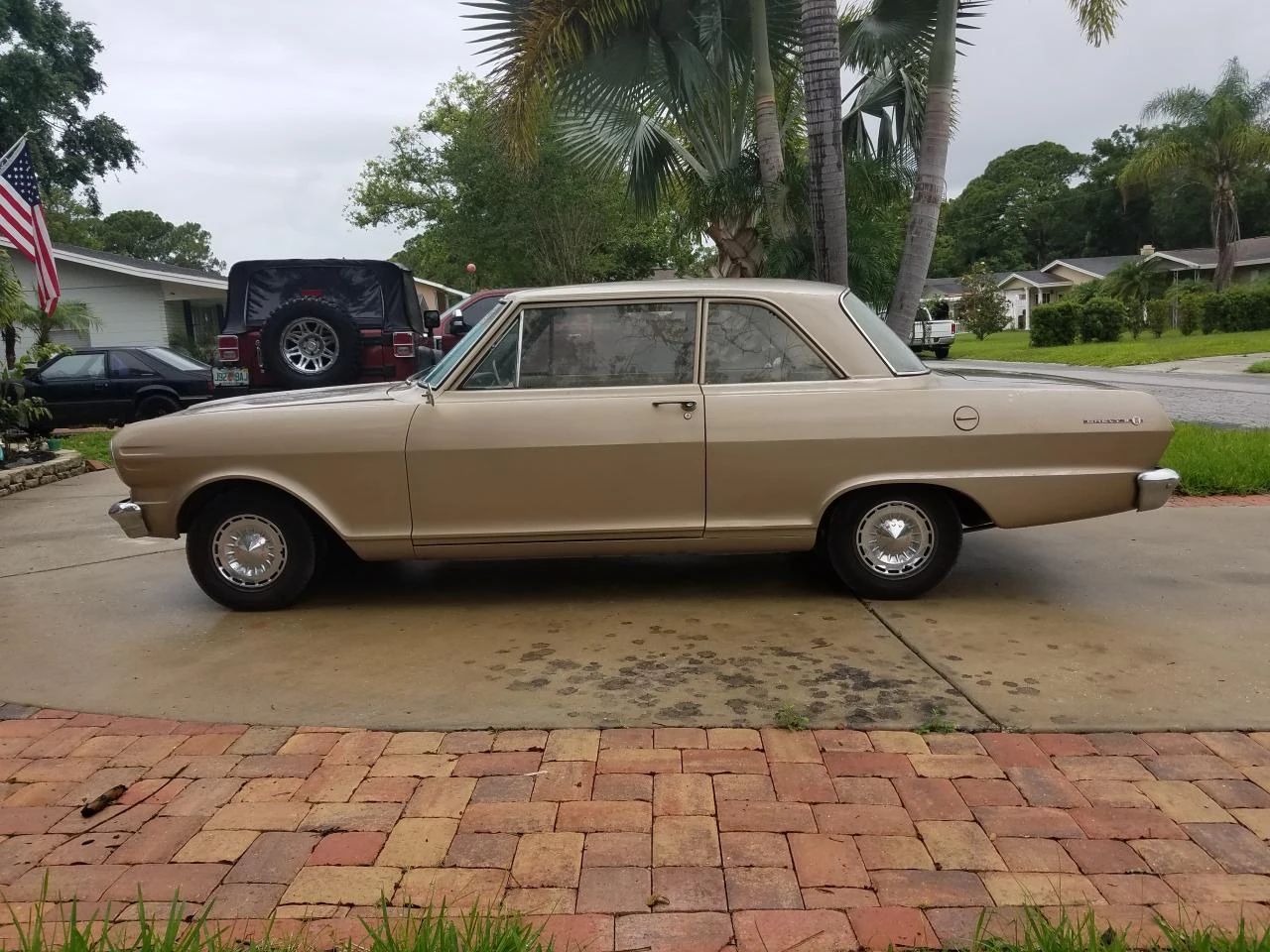Left side view of a gold 1962 Chevrolet Chevy II two-door sedan