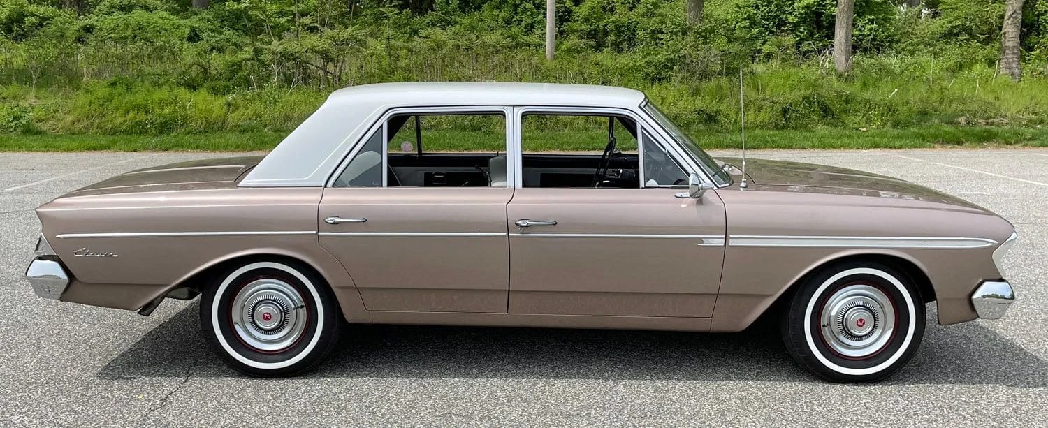 Right side view of a coral 1963 Rambler Classic sedan with a white roof