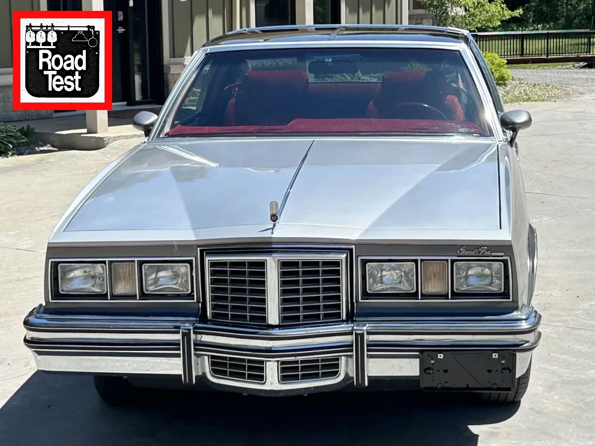 Vintage M/T Road Test: 1979 Pontiac Grand Prix SJ – Rare 4-Speed Manual In A Pontiac PLC Placeholder 1 Front view of a Platinum and Dark Charcoal 1979 Pontiac Grand Prix SJ with an overlaid graphic in the upper right reading "ROAD TEST"