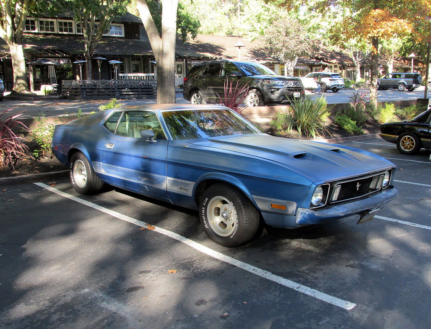 1973 Ford Mustang Mach 1: One Owner Since New, With Q-Code 351 And 4-Speed 1 Photo of a blue 1973 Ford Mustang Mach 1 fastback with aftermarket wheels, in a parking lot