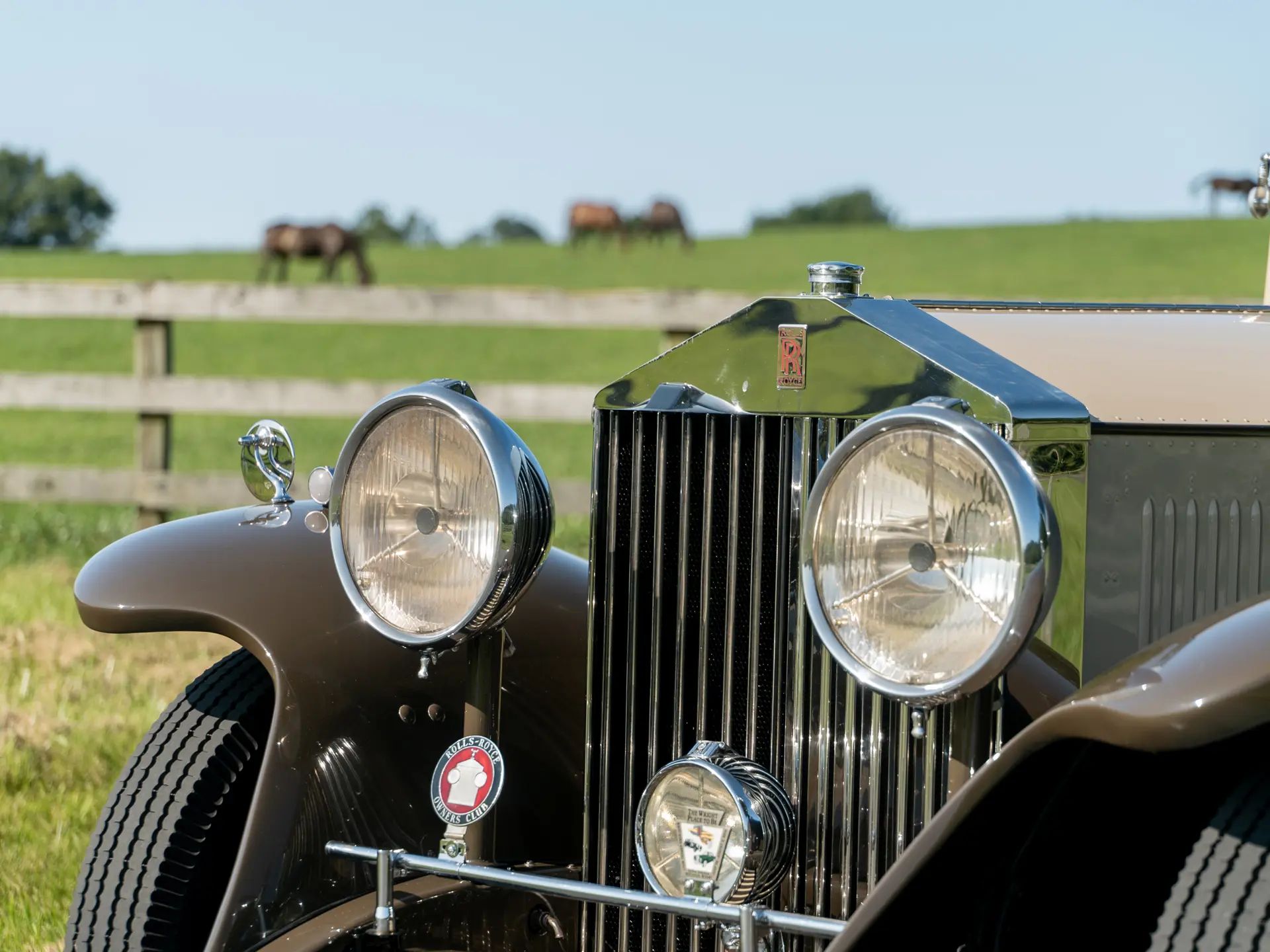 Grille and headlights of a tan 1930 Rolls-Royce Phantom II with brown fenders
