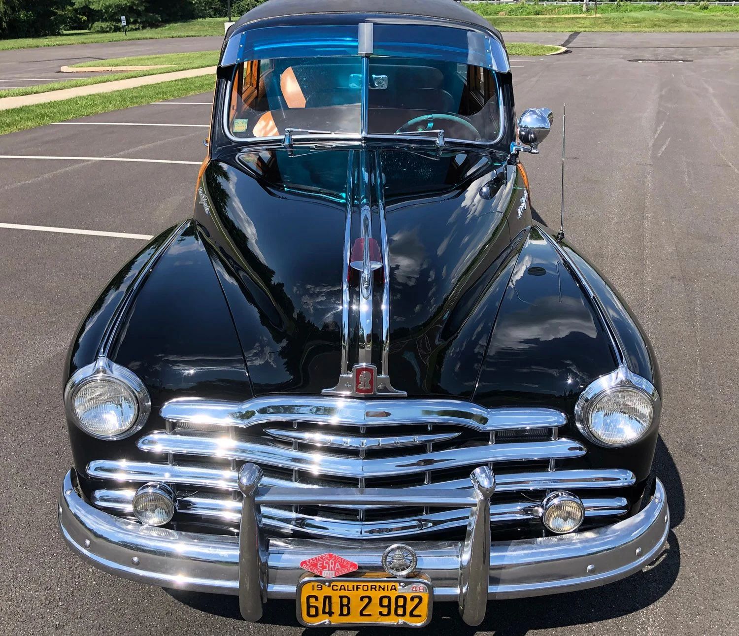 High-angle front view of a black 1948 Pontiac station wagon with an exterior sun visor